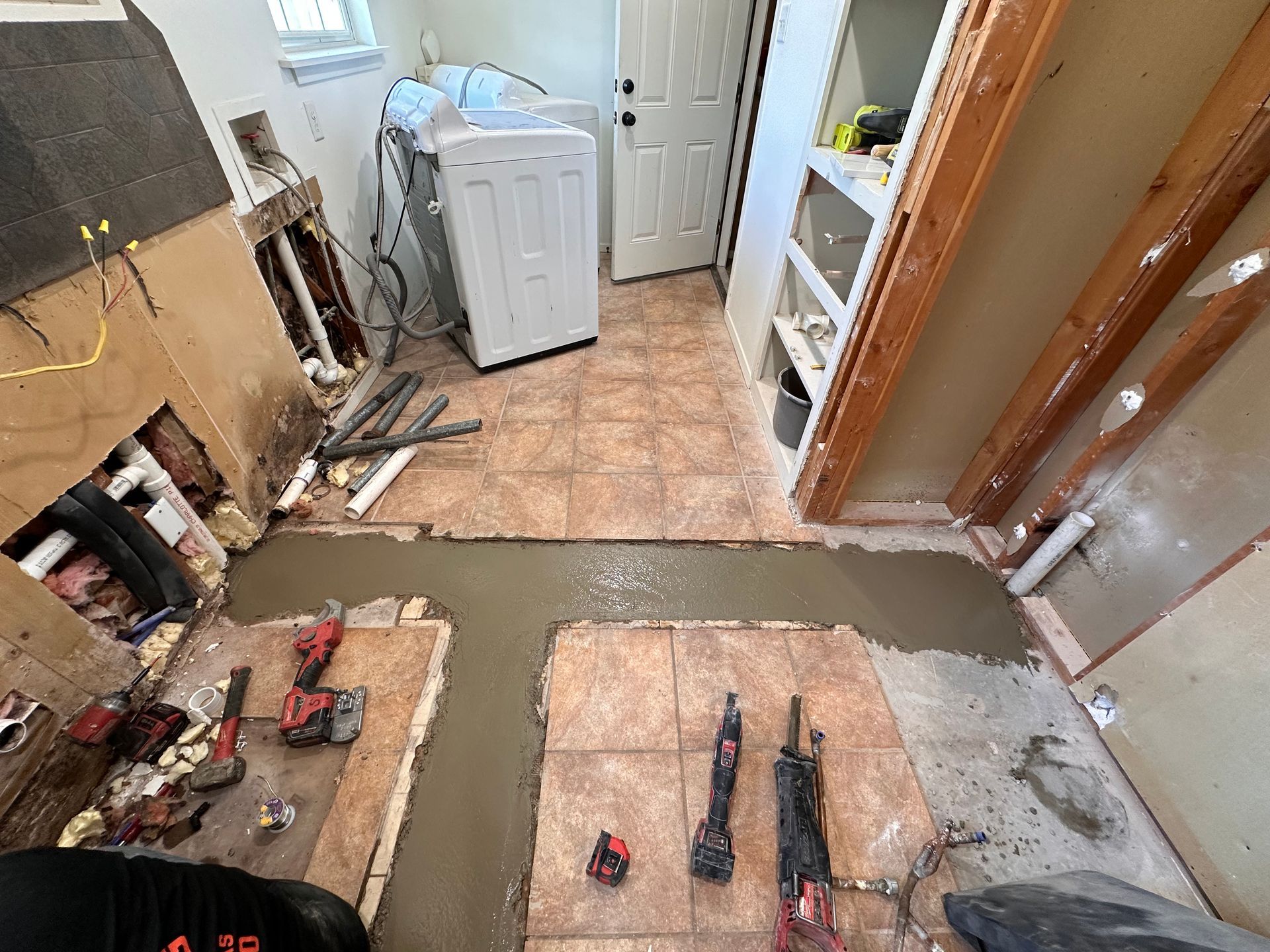 A laundry room is being remodeled with a washer and dryer.