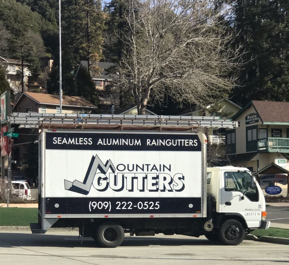 A mountain gutters truck is parked on the side of the road