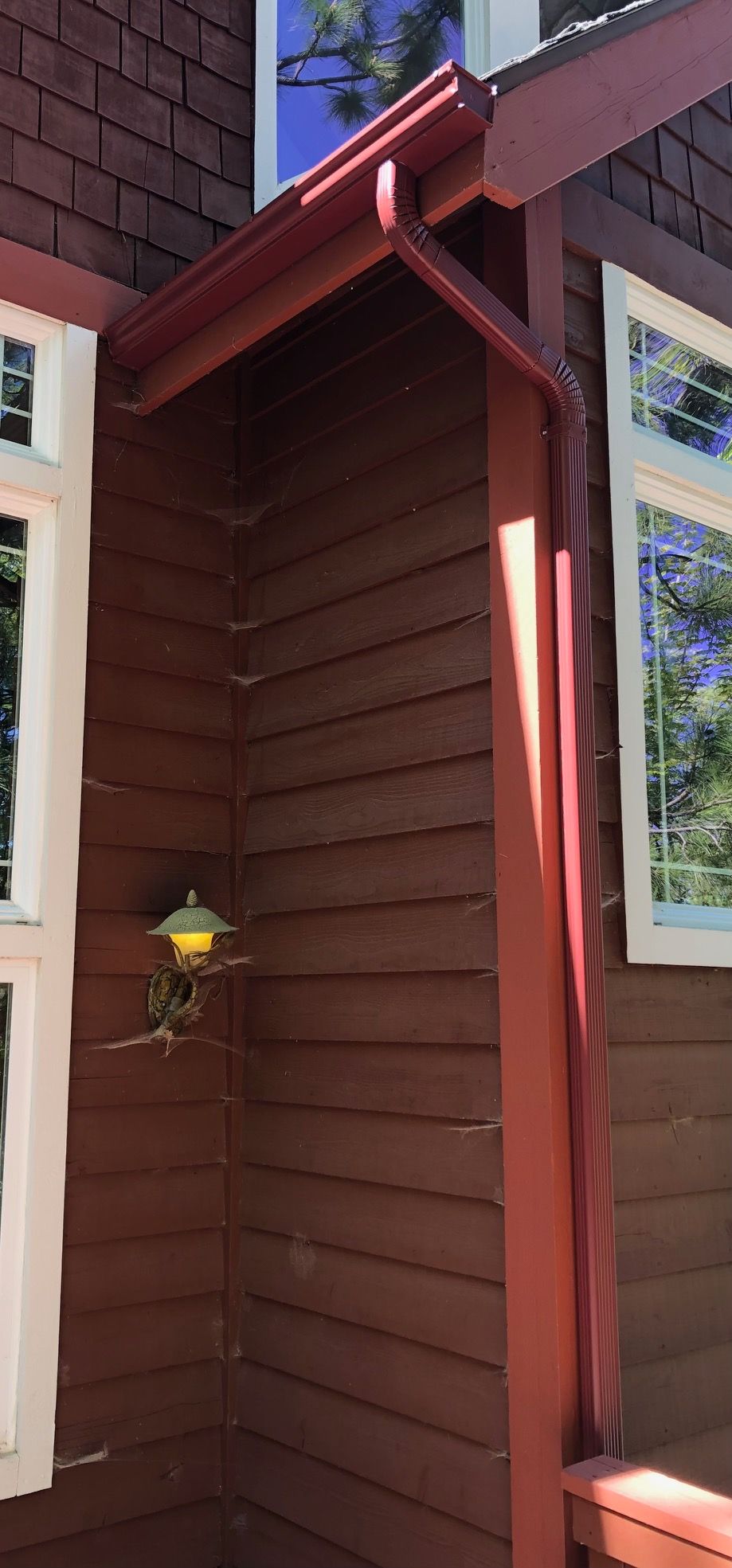 There is a lamp on the side of the house.