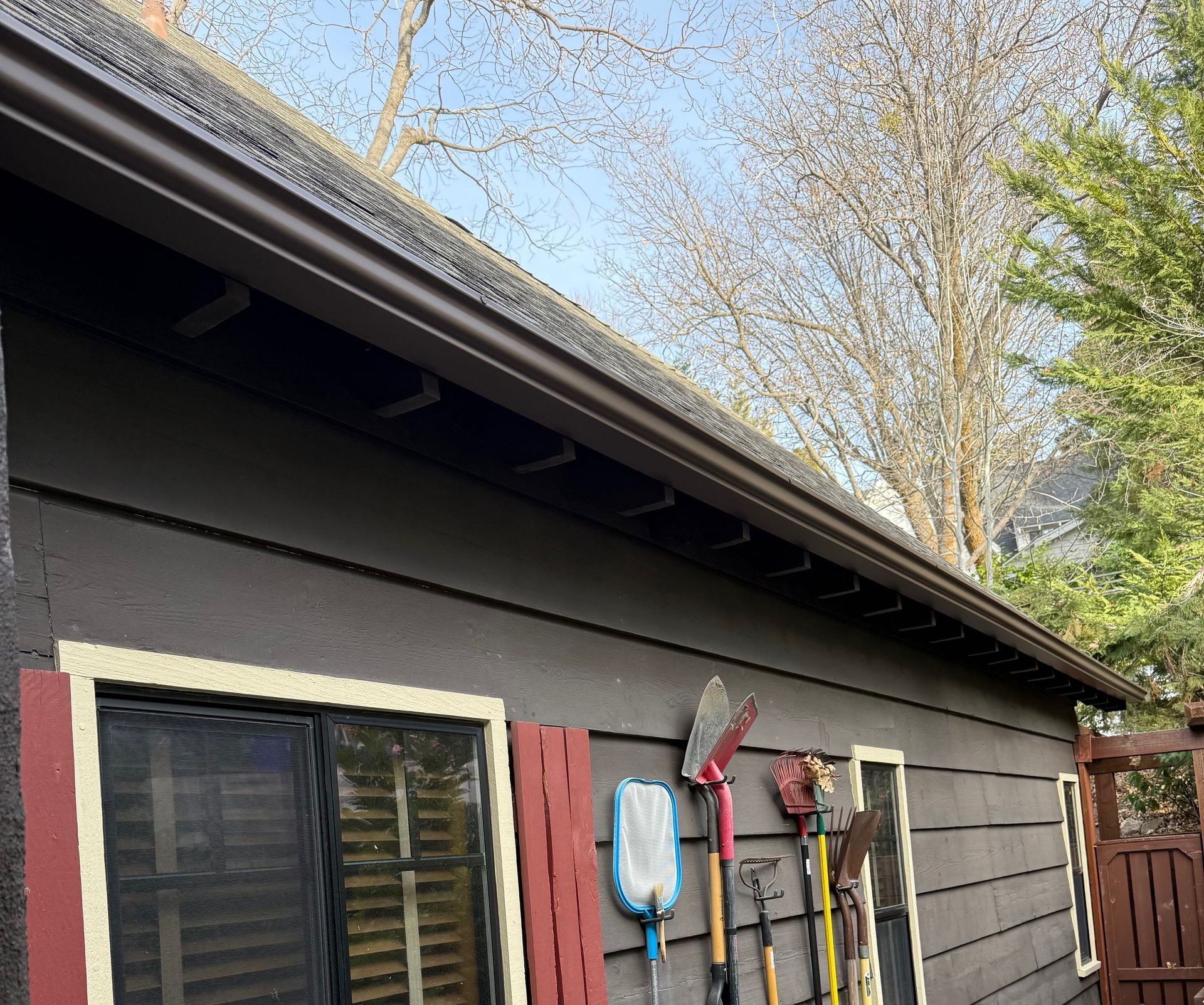 A shed with tools hanging on the side of it