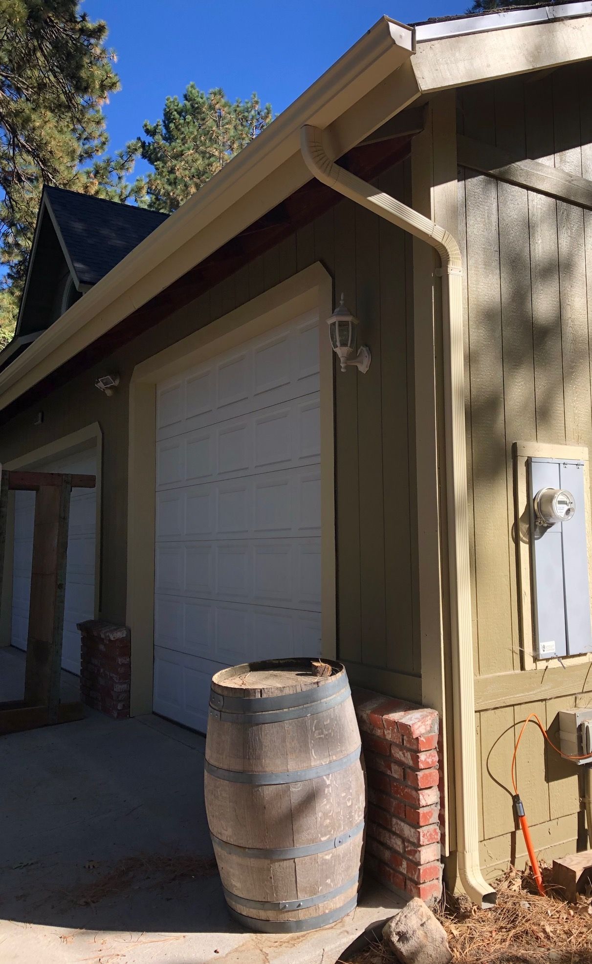 A wooden barrel is sitting in front of a garage door.