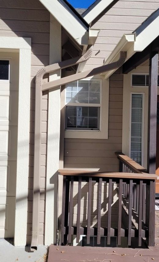 A house with a balcony and a gutter on the side of it.
