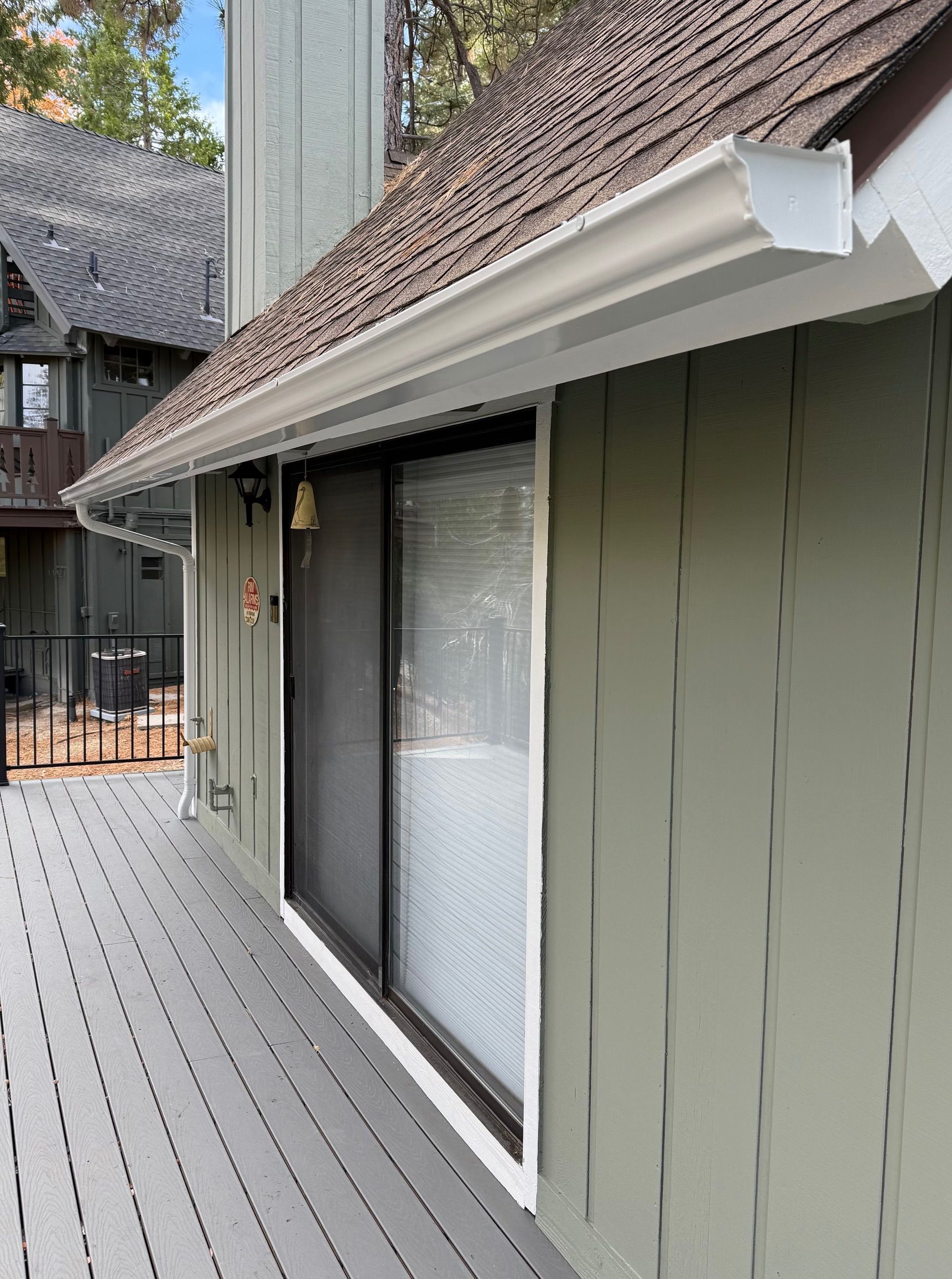 A house with a sliding glass door and a gutter on the side