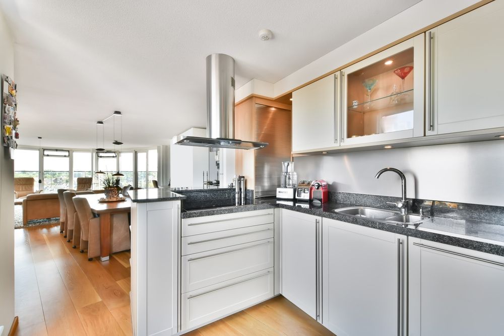 Modern kitchen with white cabinets, stainless steel appliances, and wood flooring. — Dimond J Carpentry in Sunshine Coast, QLD
