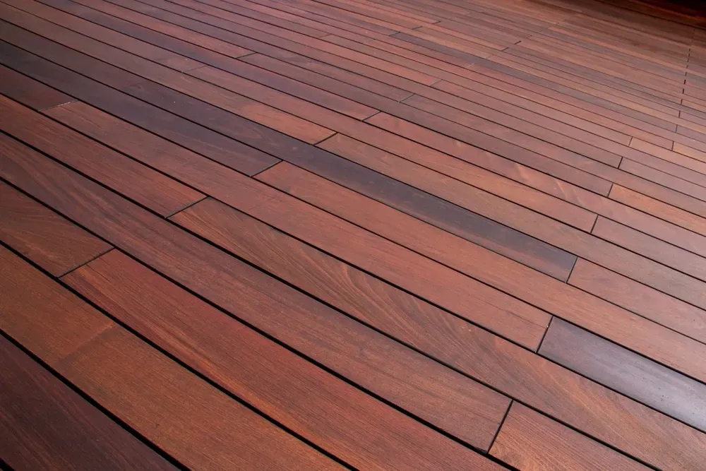 Wooden floorboards, reddish-brown hue, with dark grooved lines between them. — Dimond J Carpentry in Sunshine Coast, QLD