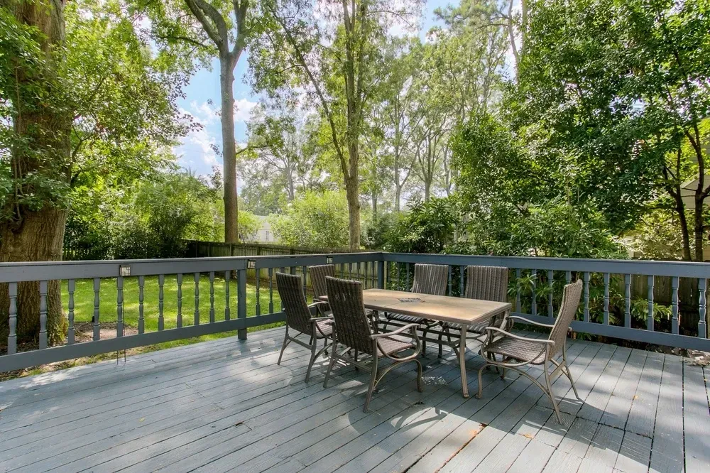 Wooden deck with table and chairs, surrounded by trees and greenery. — Dimond J Carpentry in Bli Bli, QLD