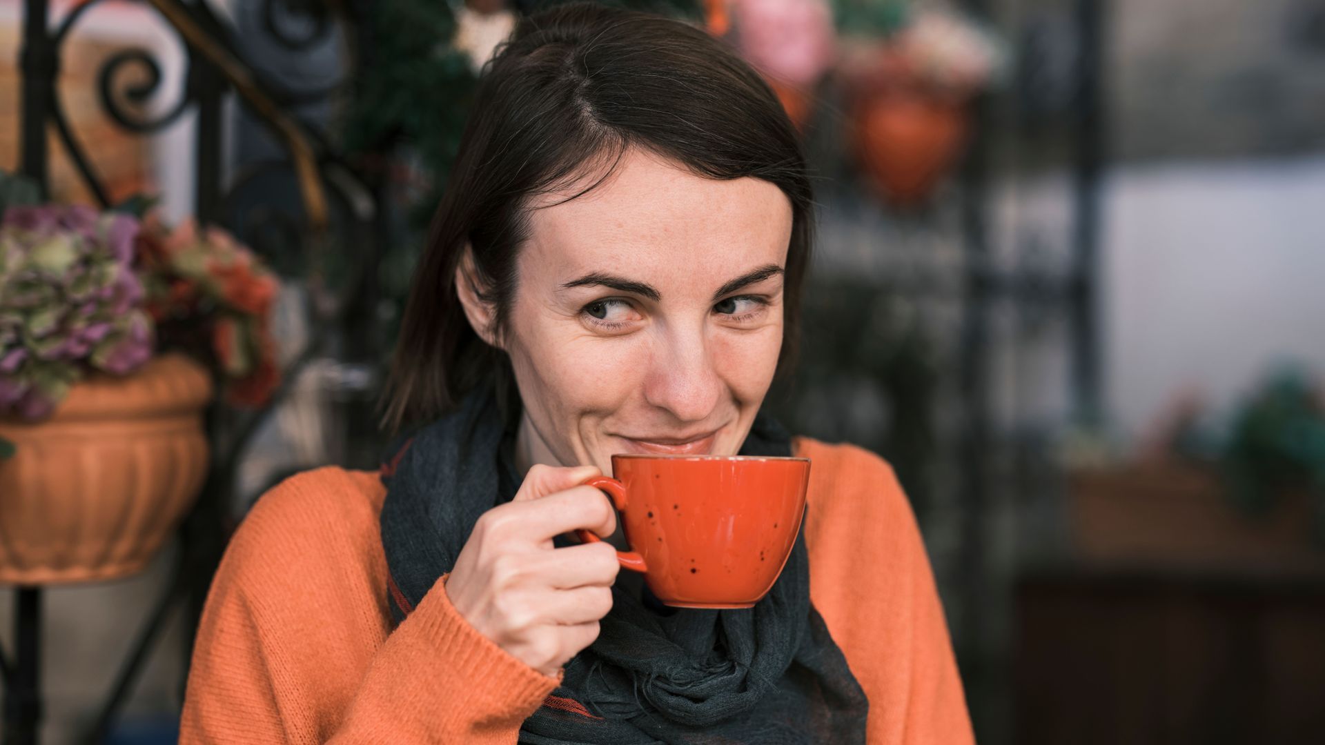 Kopje latte met latte art op een schoteltje en een lepel. 