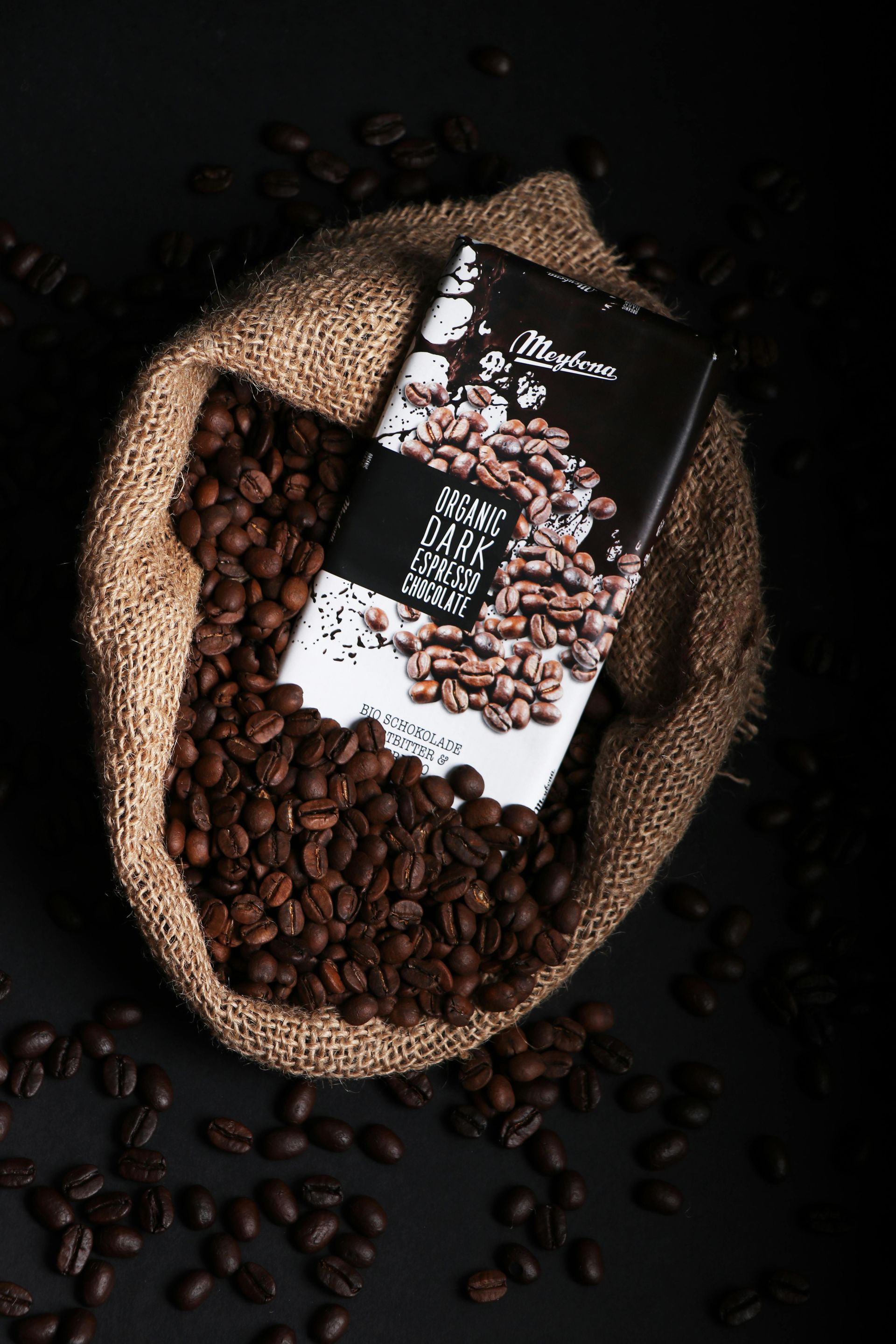 Kopje latte met latte art op een schoteltje en een lepel.