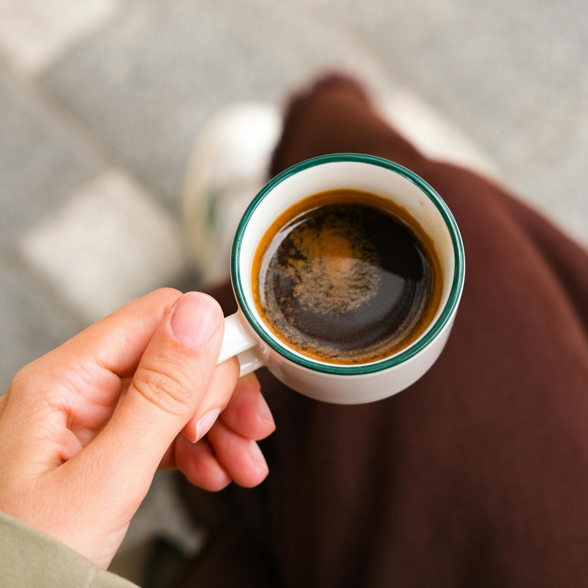 Handen houden een handvol kleurrijke koffiebessen vast, geplukt uit een mand.
