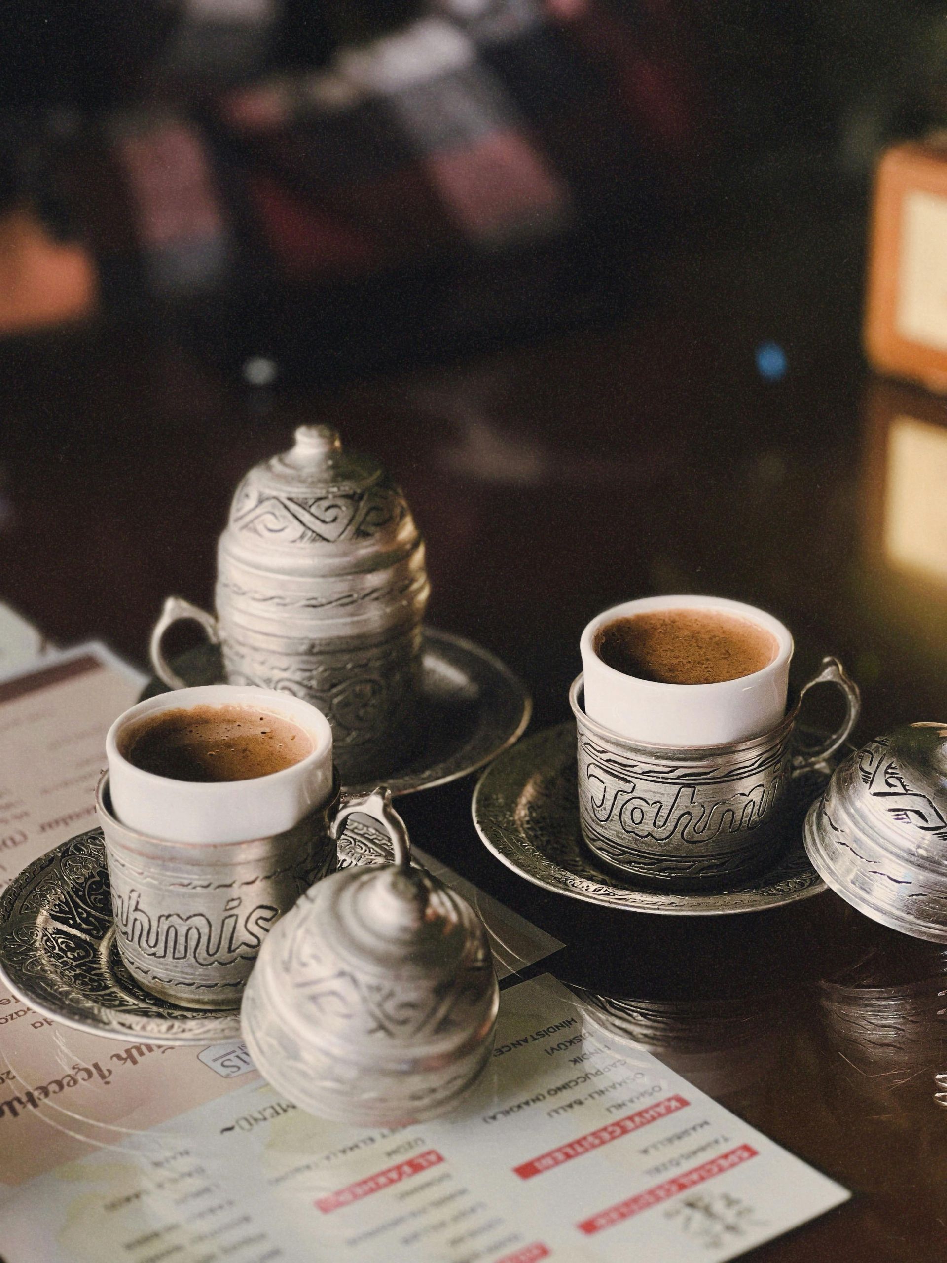 Kopje latte met latte art op een schoteltje en een lepel. 