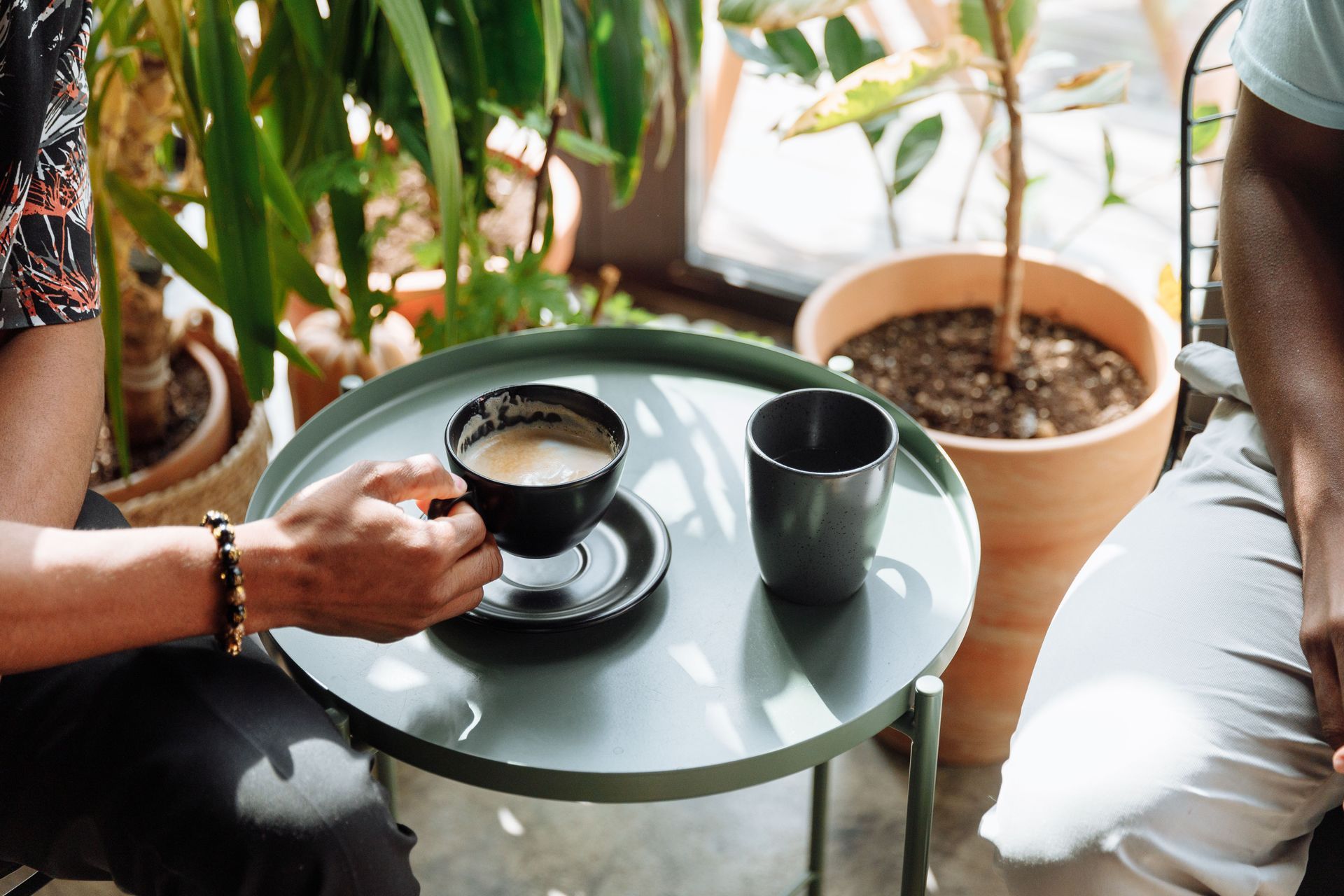 Kopje latte met latte art op een schoteltje en een lepel.