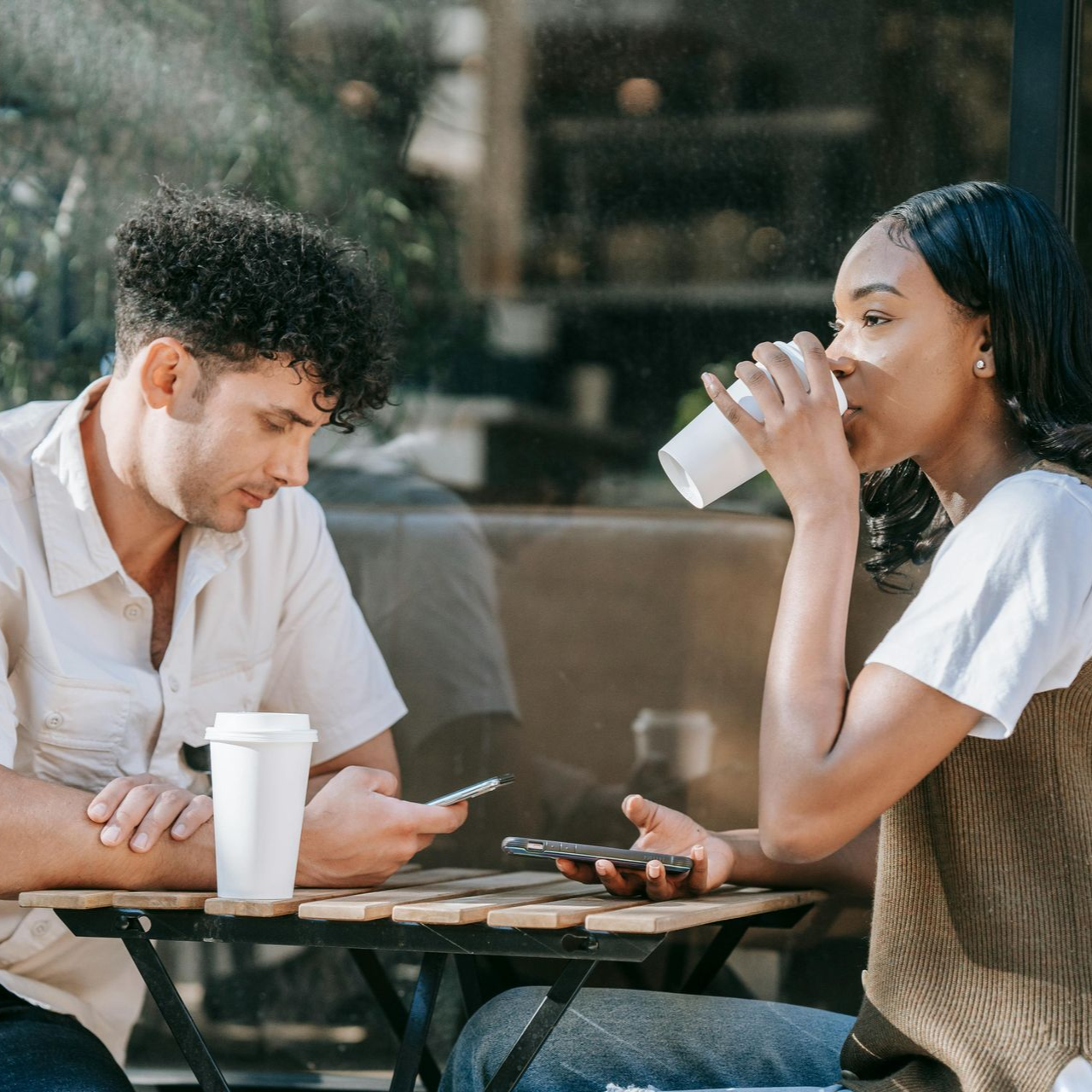 Kopje latte met latte art op een schoteltje en een lepel. 