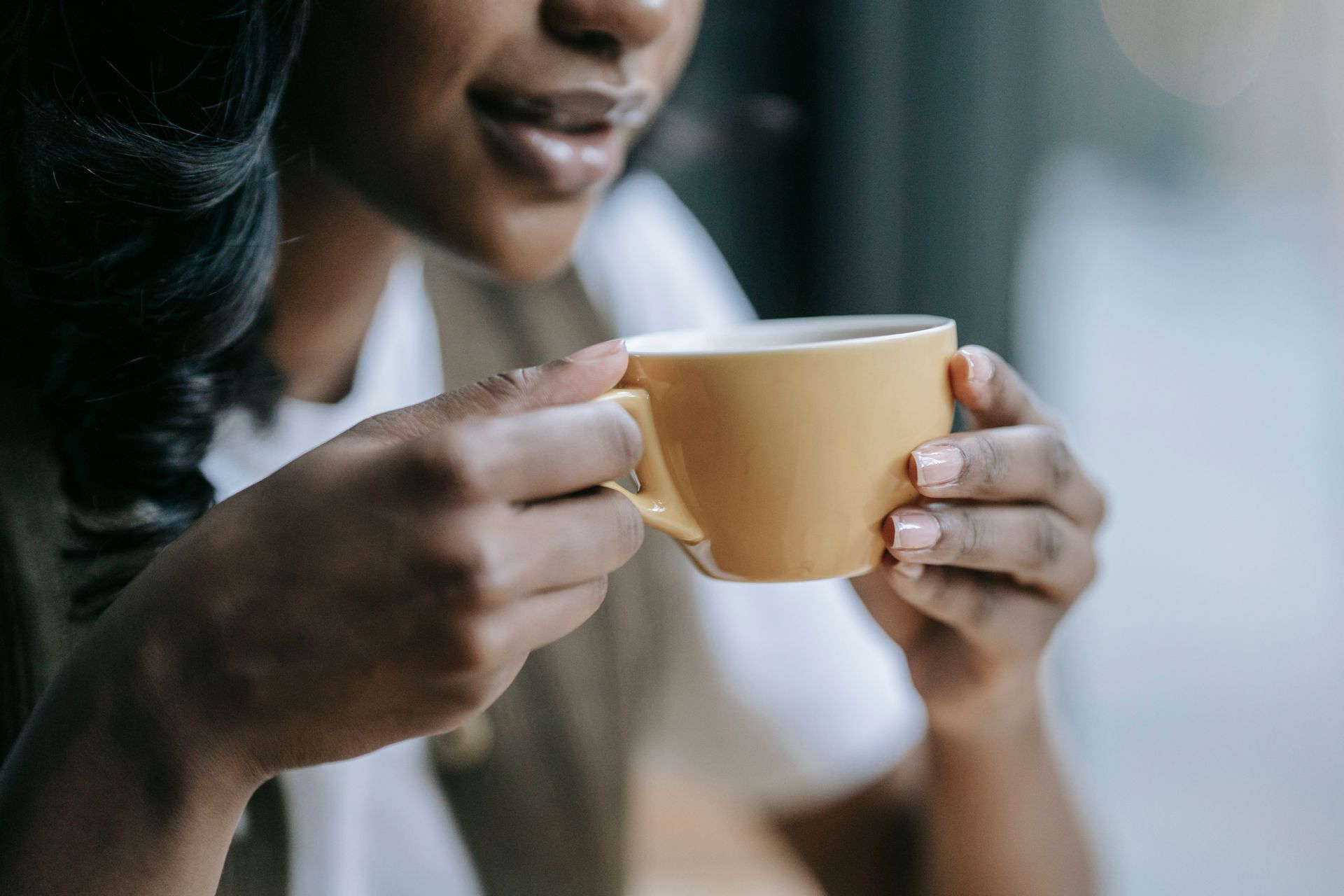 Kopje latte met latte art op een schoteltje en een lepel. 