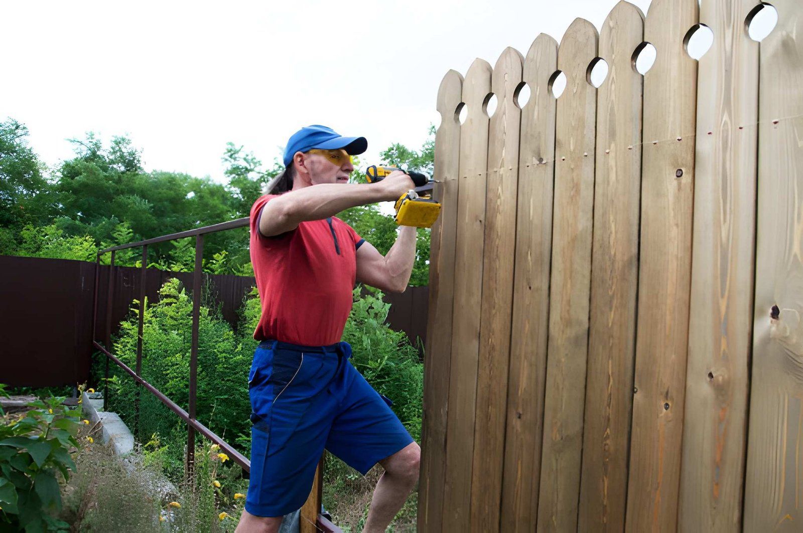 Man repairing a wooden fence panel