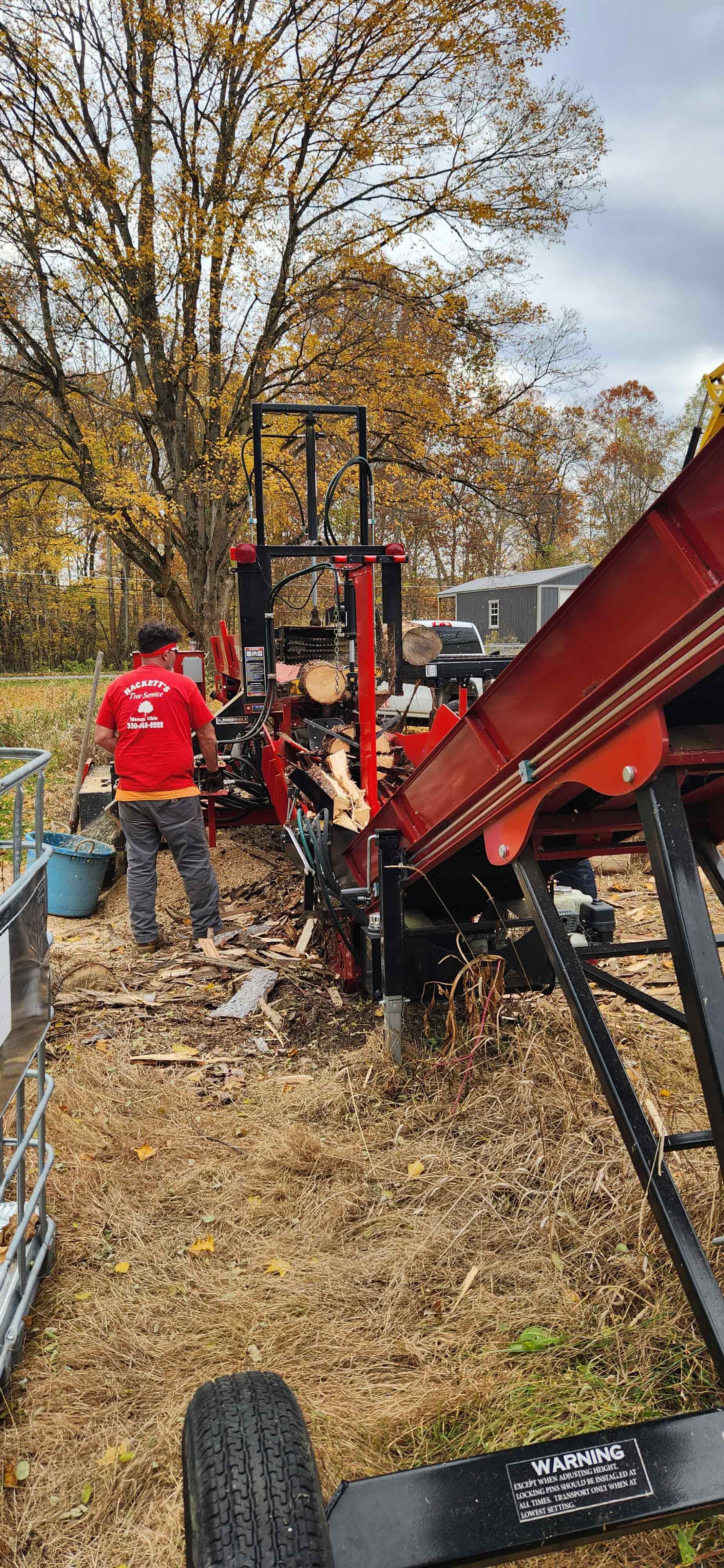 Man is Standing Next to a Machine — Masury, OH — Hackett's Tree Service
