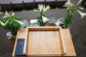 Podium with lilies and a Bible in a church setting.