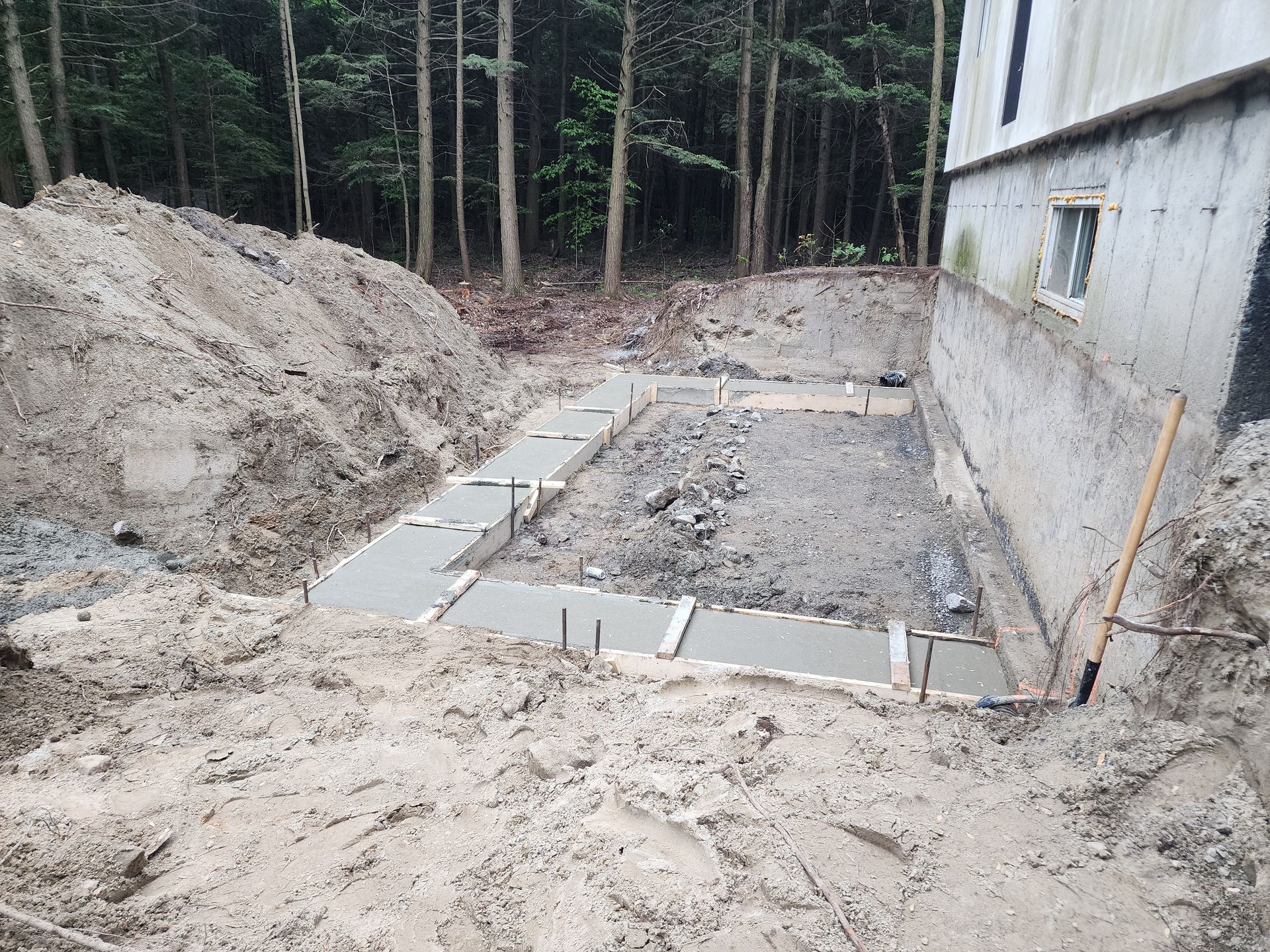 Un gros tas de terre se trouve devant une maison en construction.