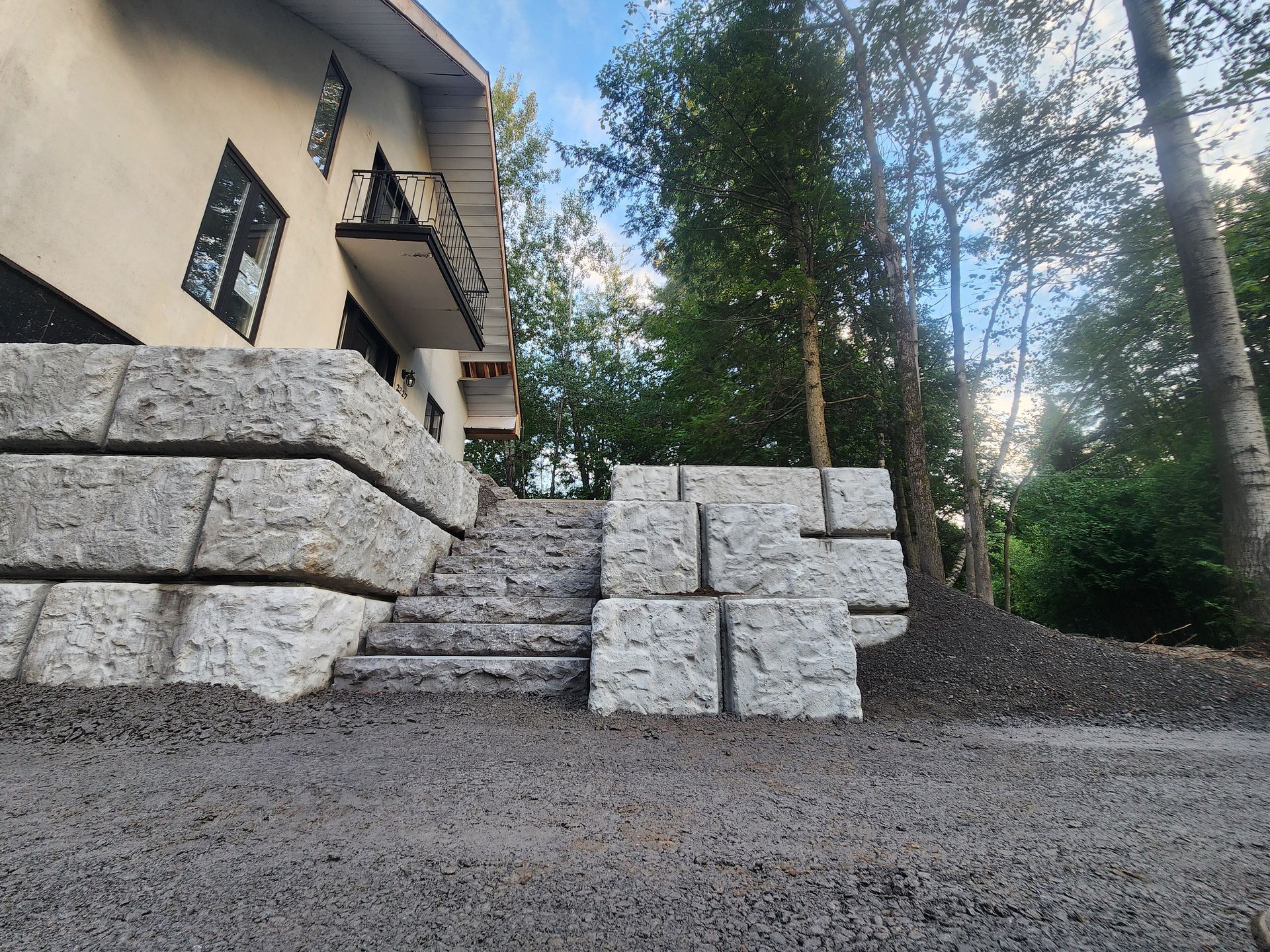 Une maison avec un mur de pierre et des escaliers devant
