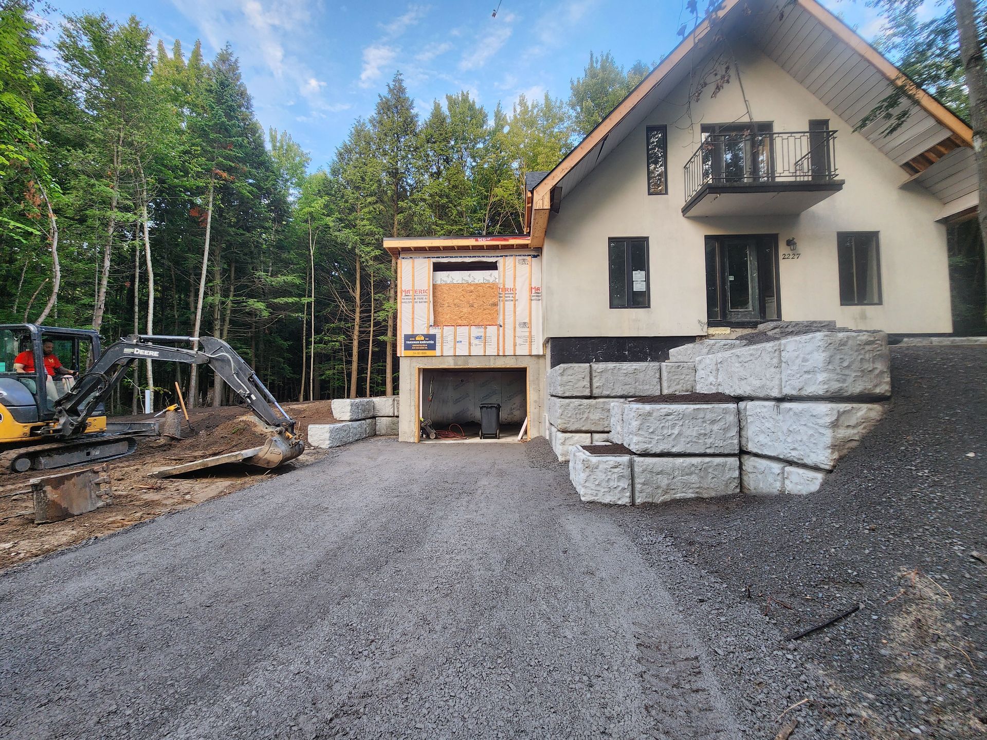 Une grande maison est en construction au milieu d'une forêt.
