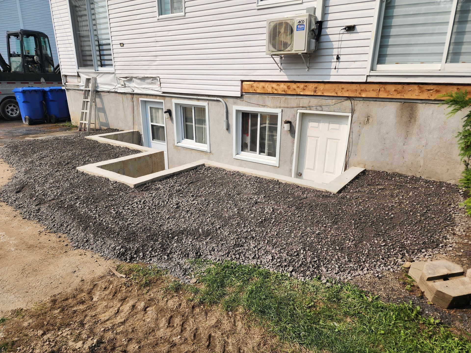 Une maison avec beaucoup de fenêtres et du gravier devant.