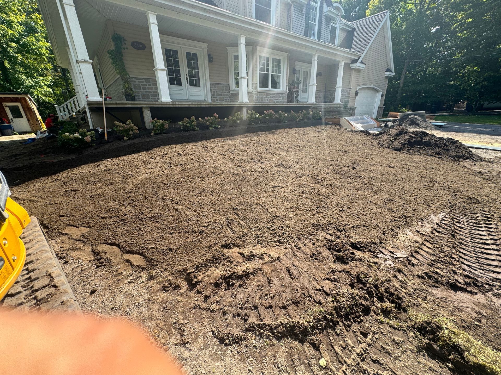 Une grande maison avec beaucoup de terre devant.