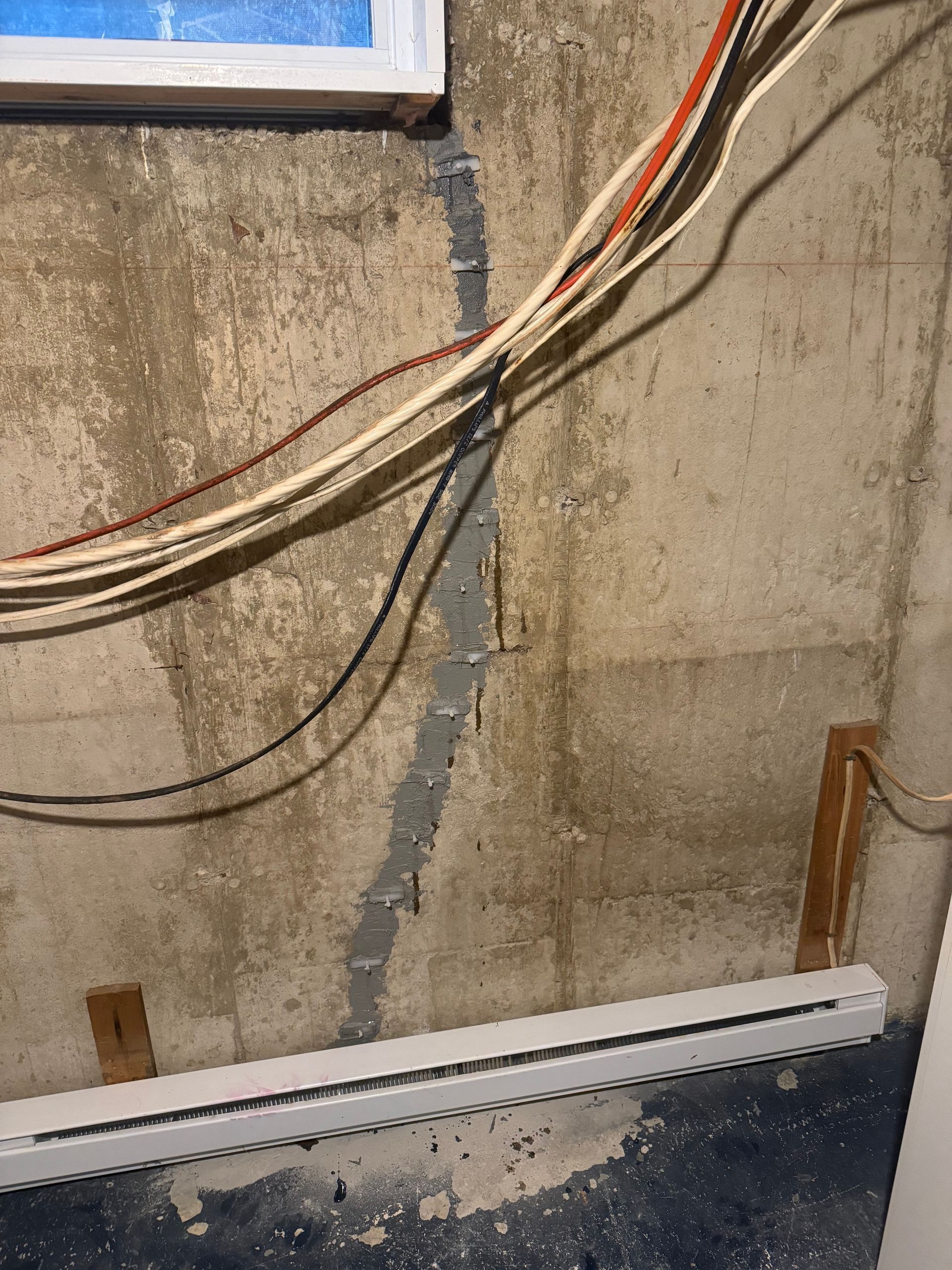 Un mur en béton avec beaucoup de fils qui y pendent.