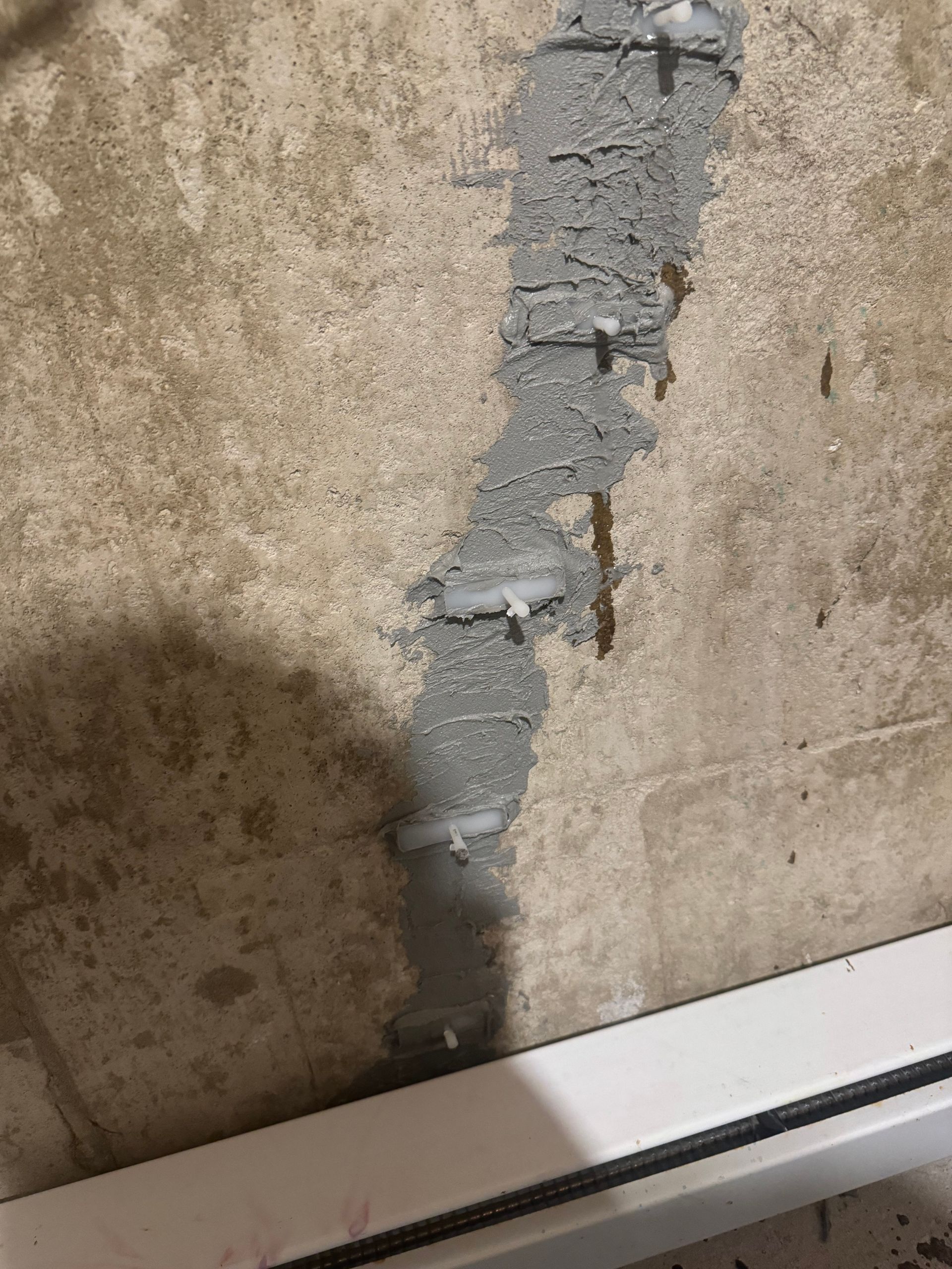 Un gros plan d'un mur en béton avec une garniture blanche.