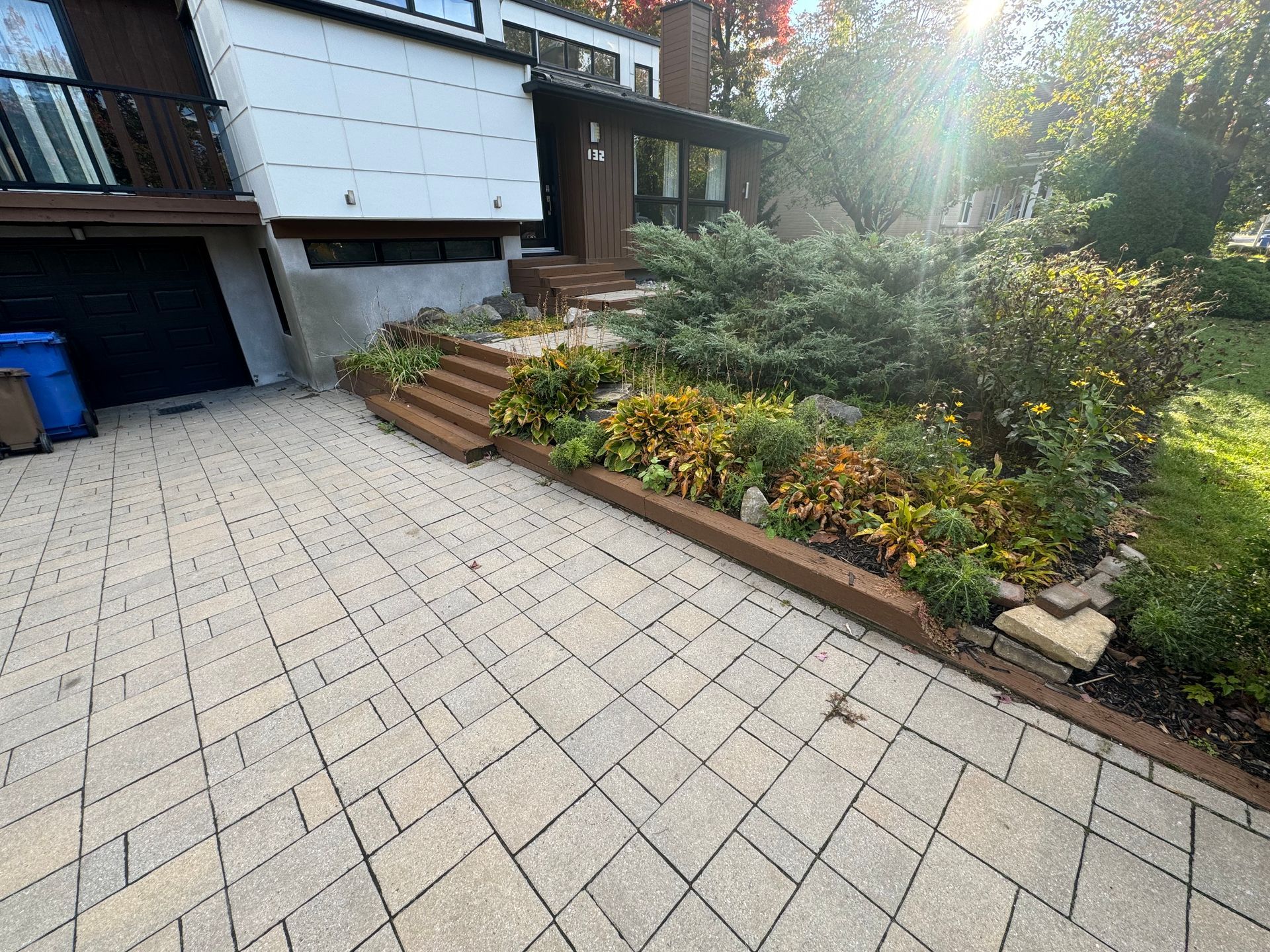 Une allée en briques menant à une maison avec un jardin devant.