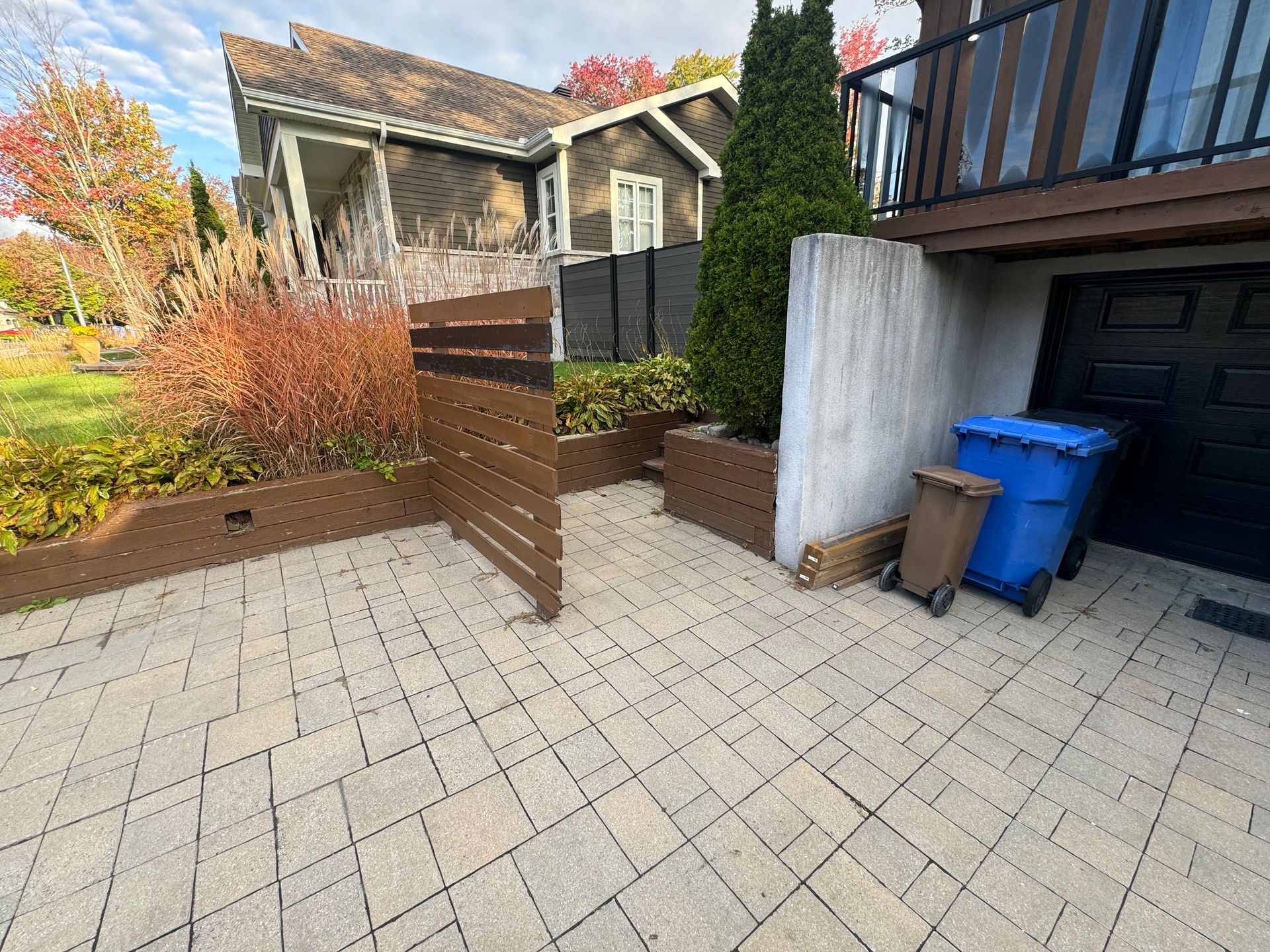 Il y a deux poubelles devant une maison.