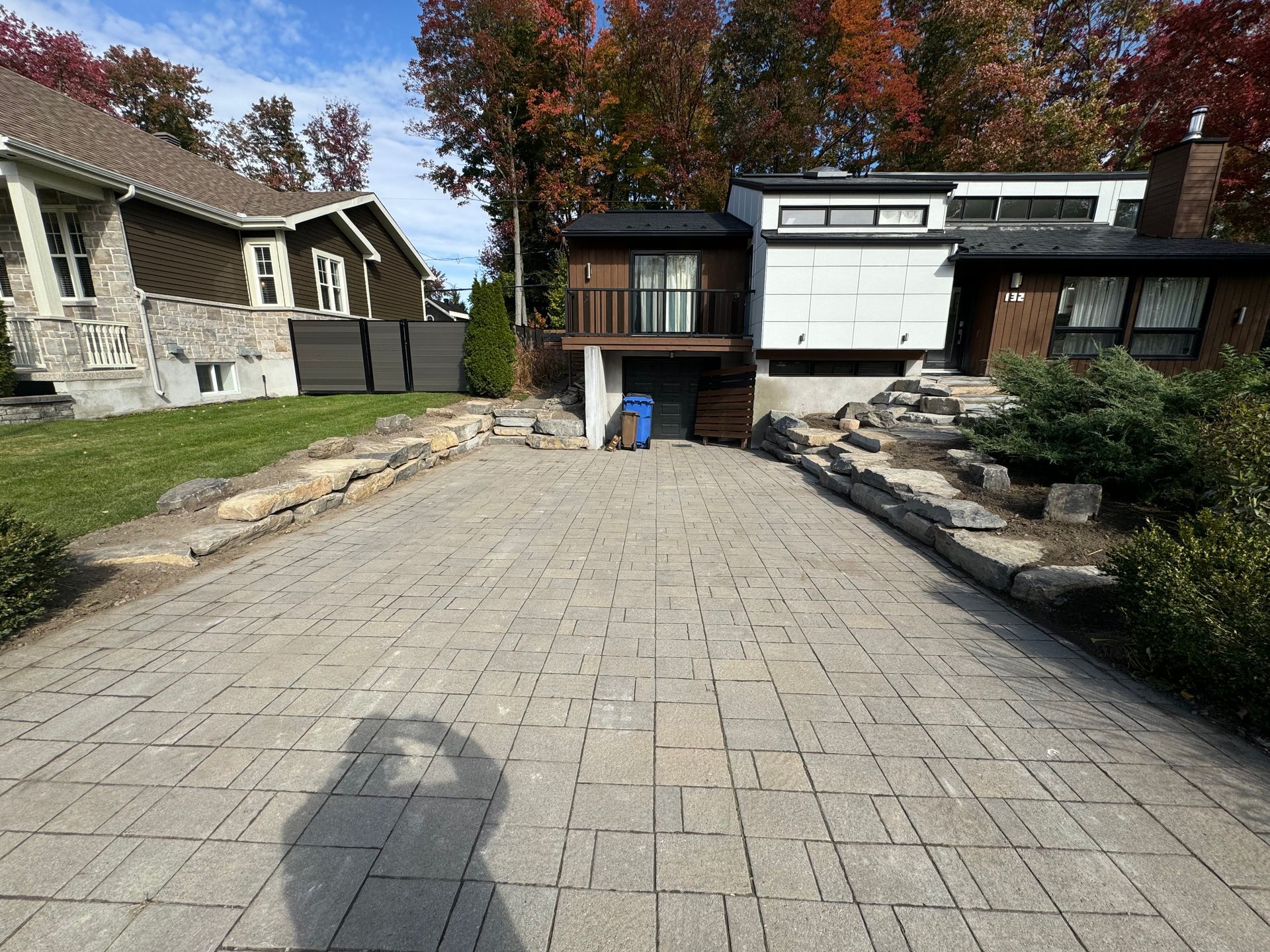 Une allée en briques menant à une maison avec des arbres en arrière-plan