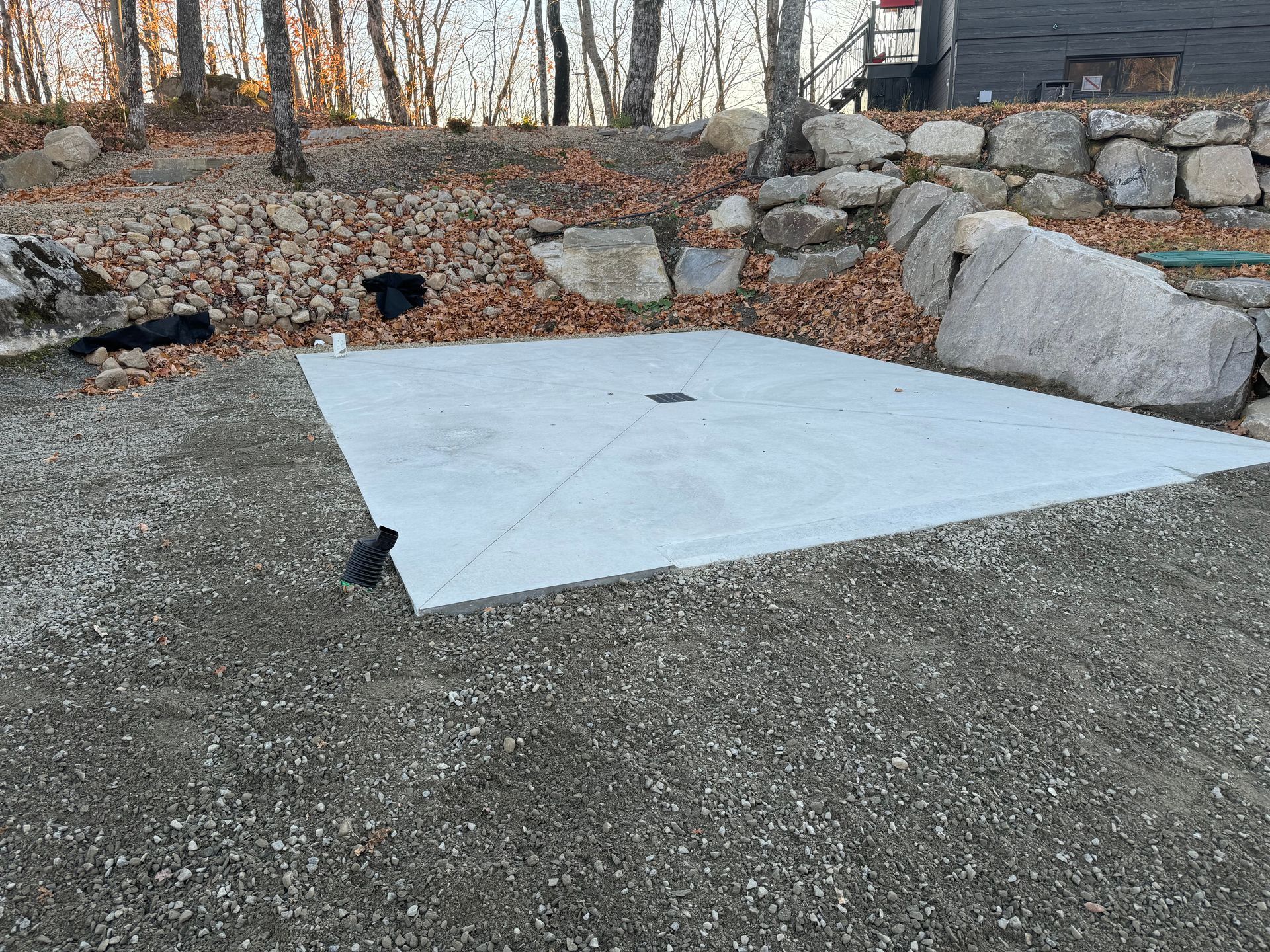Une grande dalle de béton repose sur une route de gravier.