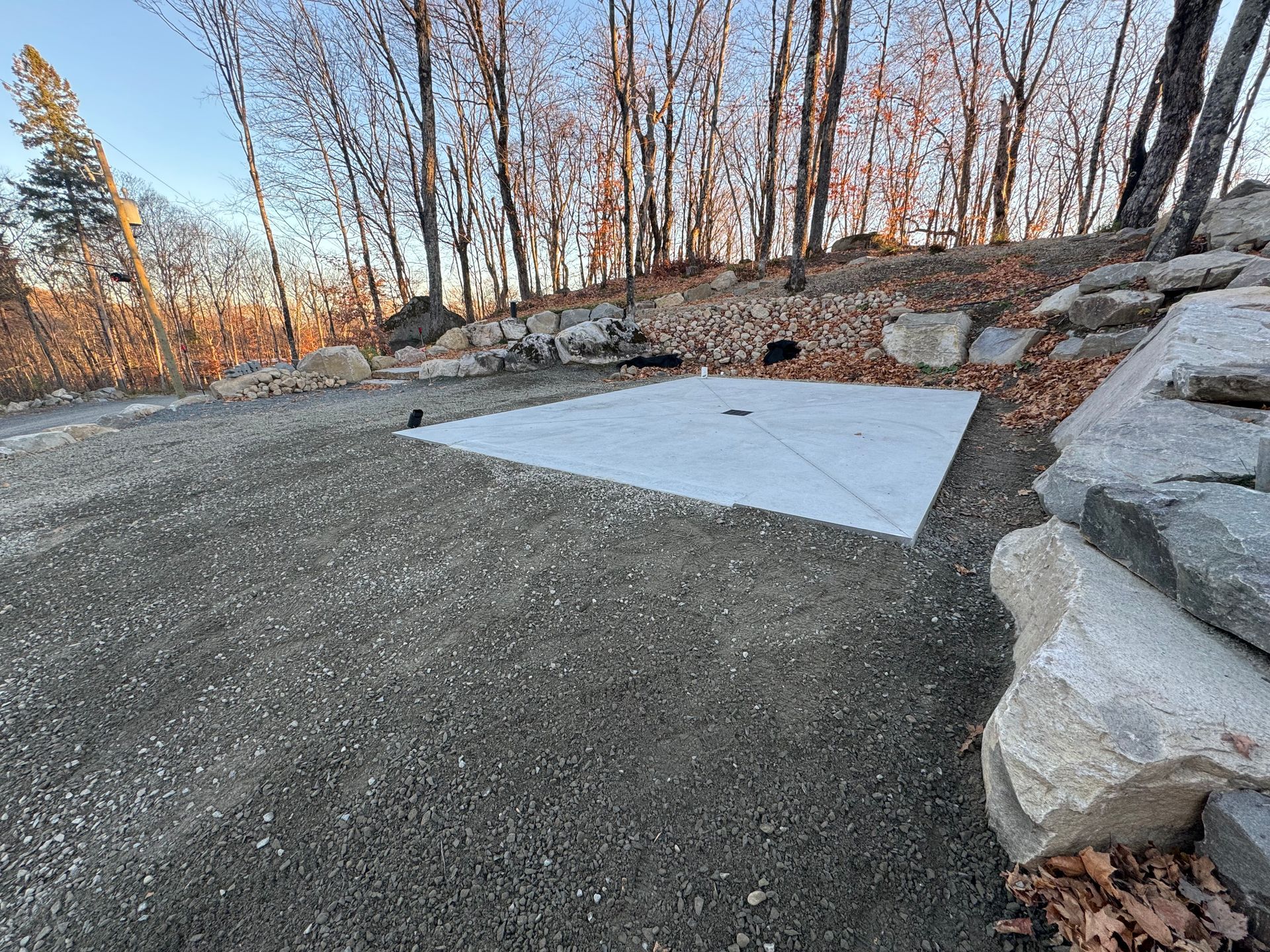 Un bloc de béton est posé sur le sol à côté d'un mur de pierre.