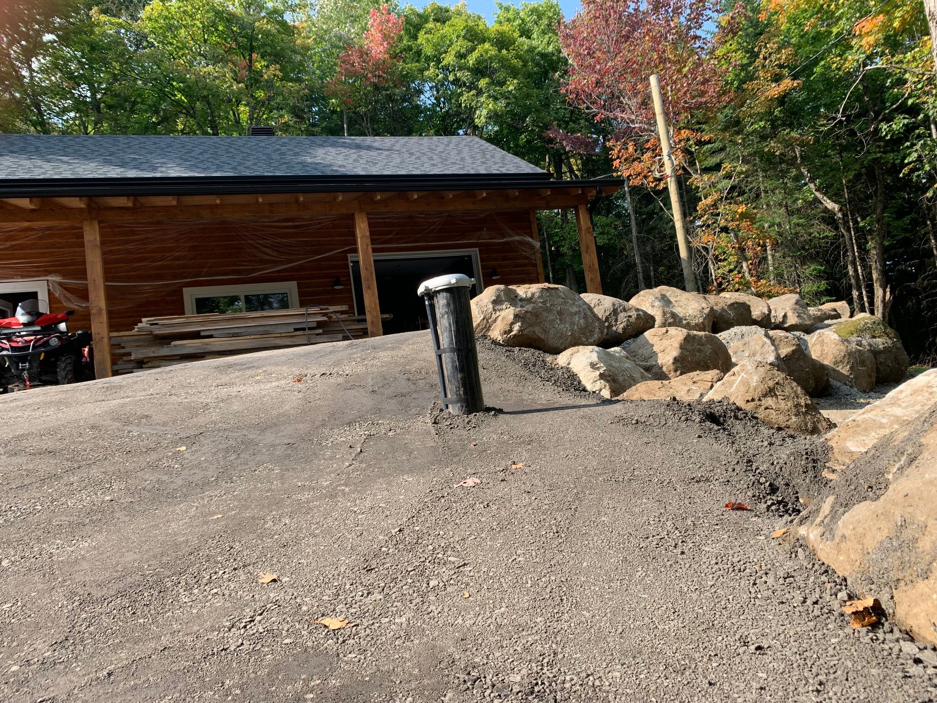 Un grand mur de pierre est en train d'être construit devant une maison.