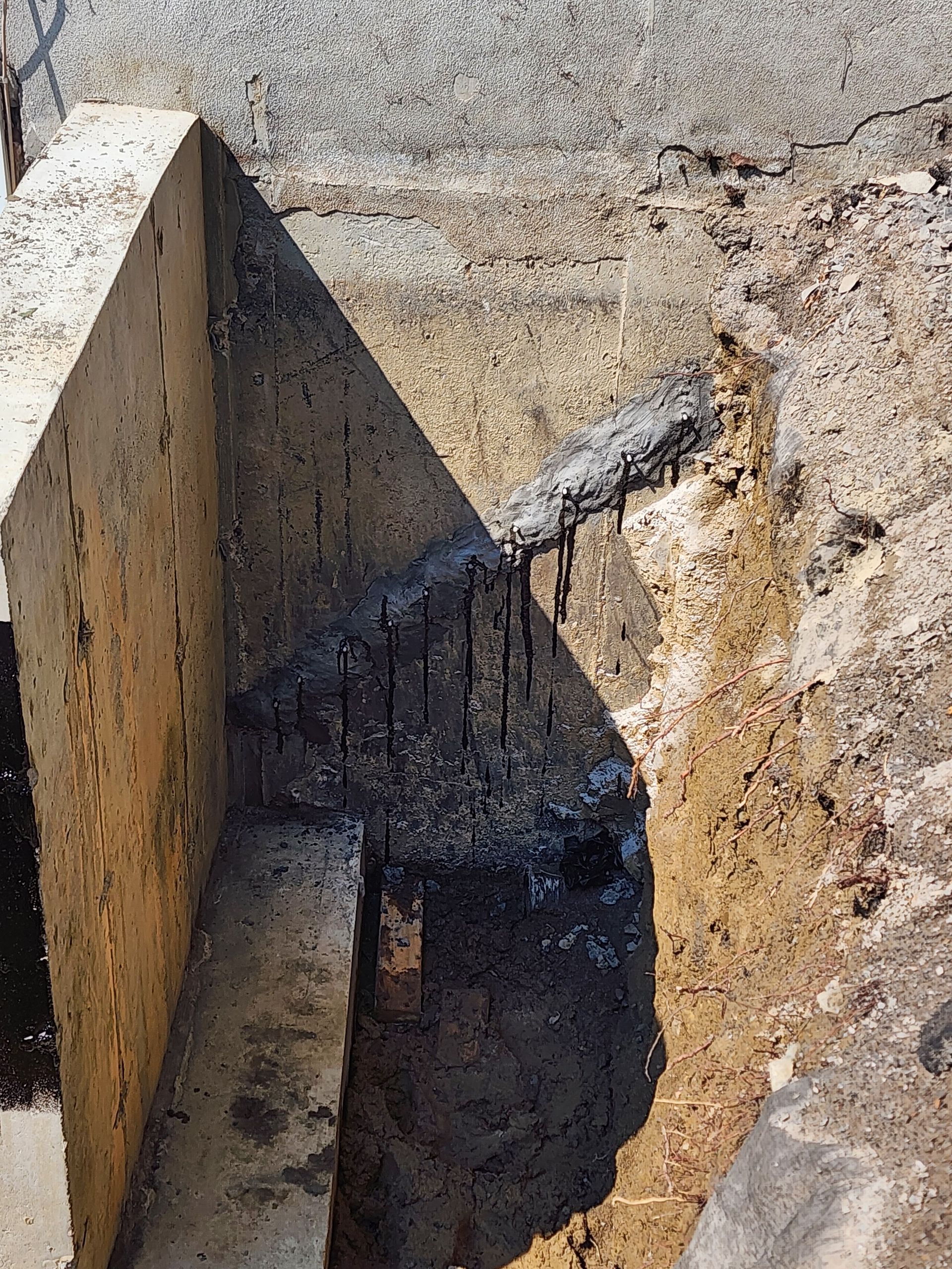 Un gros plan d'un mur en béton avec une ombre sur le sol.