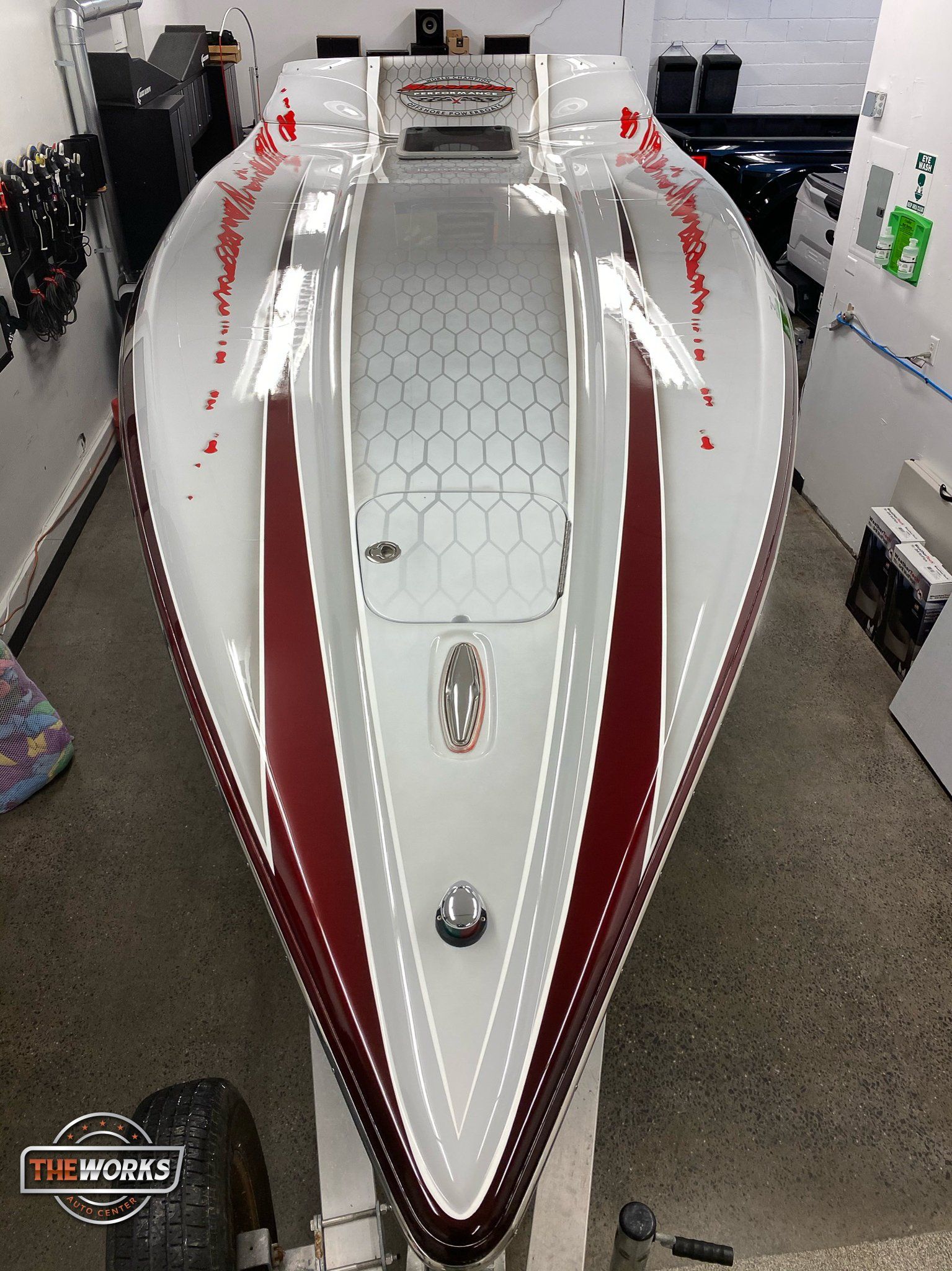 A white and red boat is sitting on a trailer in a garage.