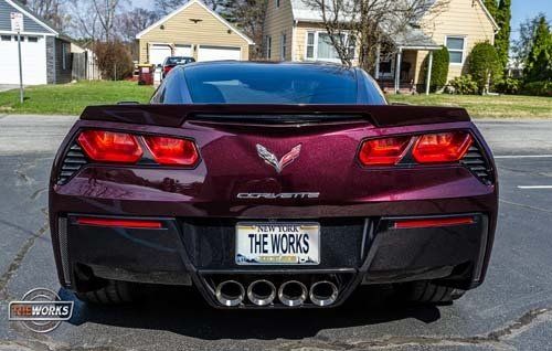 A purple corvette with a license plate that says the works