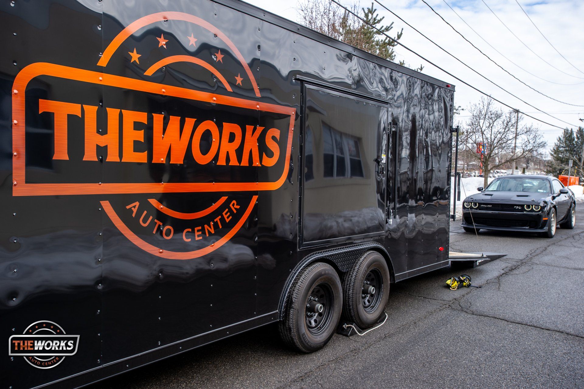 A black trailer with the words theworks auto center on it
