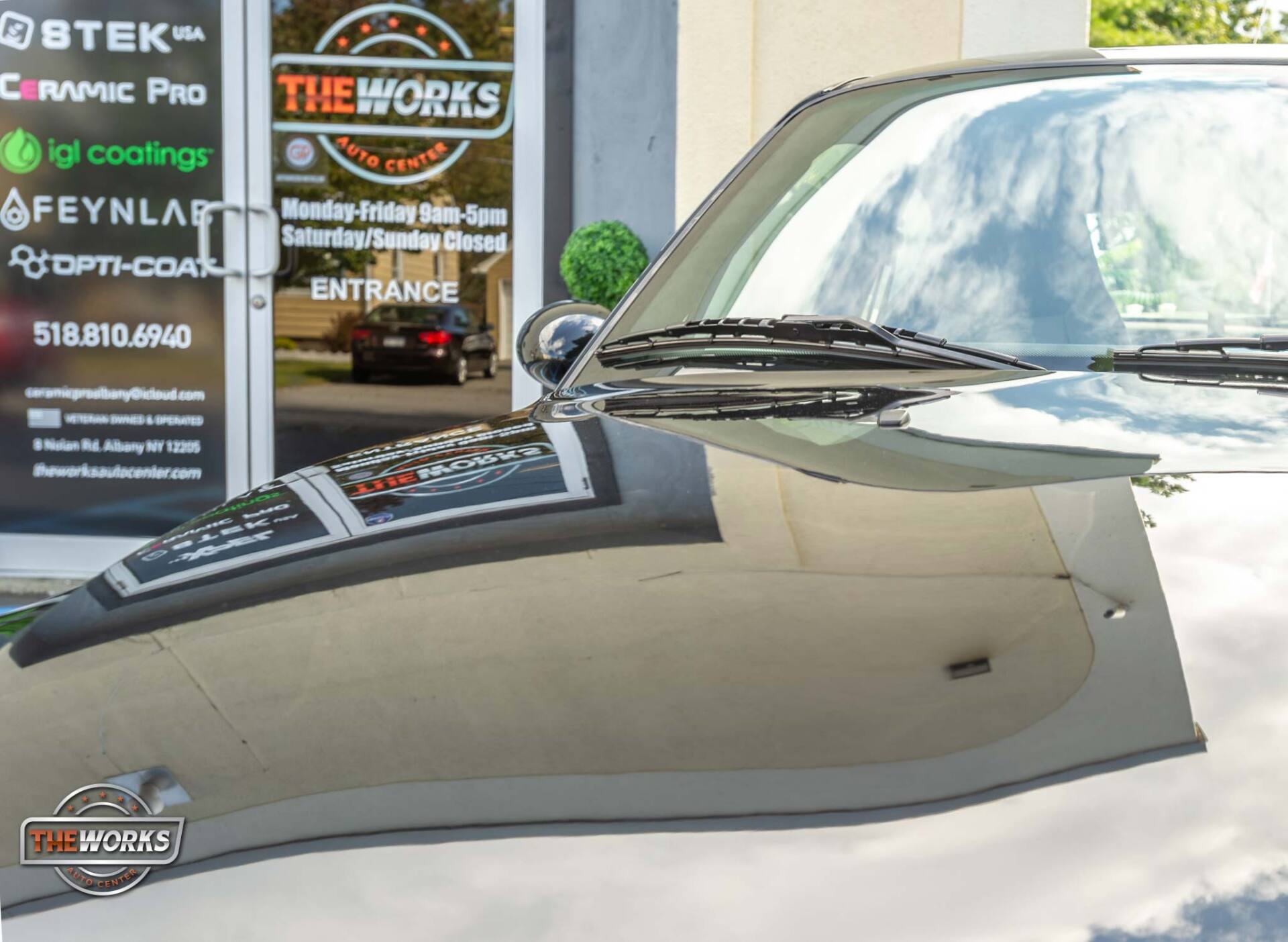 Black car reflecting a shop entrance with