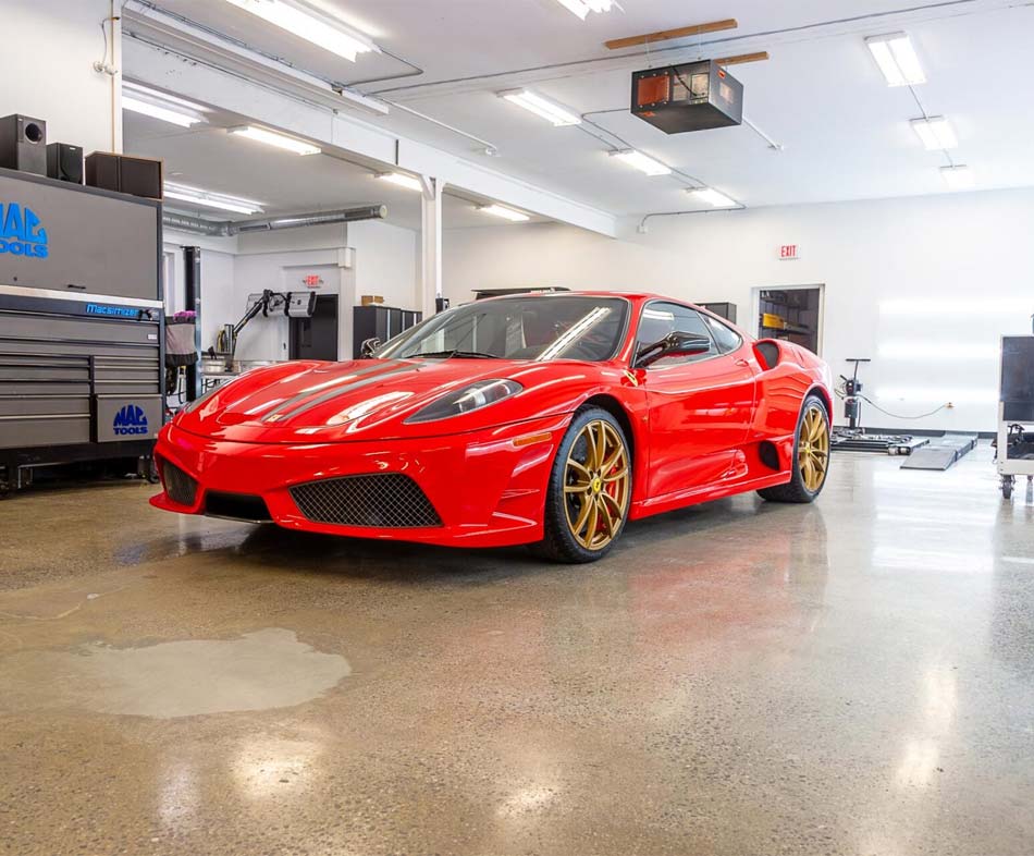 A red sports car is parked in a garage.