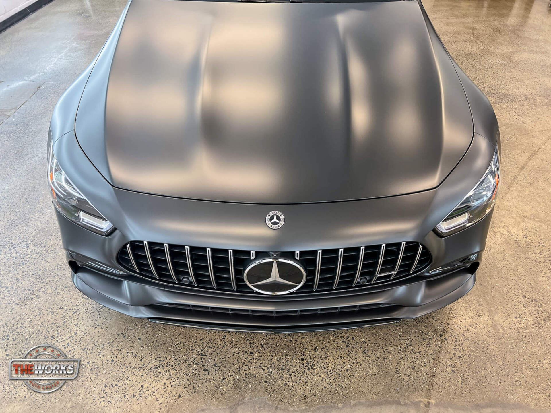 The front of a mercedes benz amg gt 63 s is shown in a showroom.
