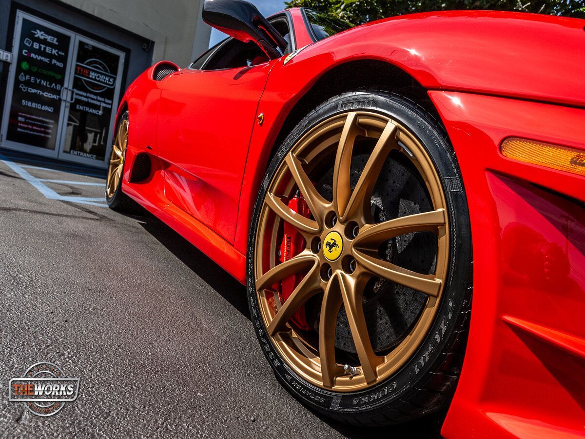 Red Ferrari with gold wheels parked