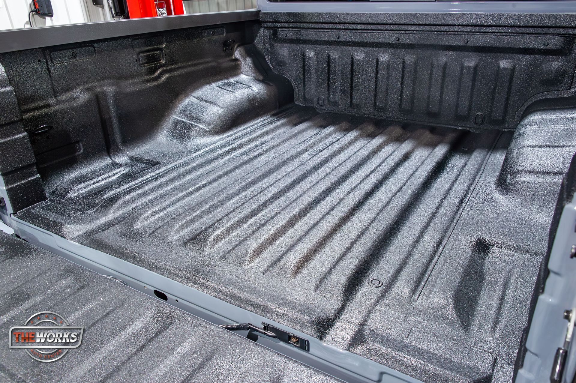 The bed of a truck is painted black and gray.