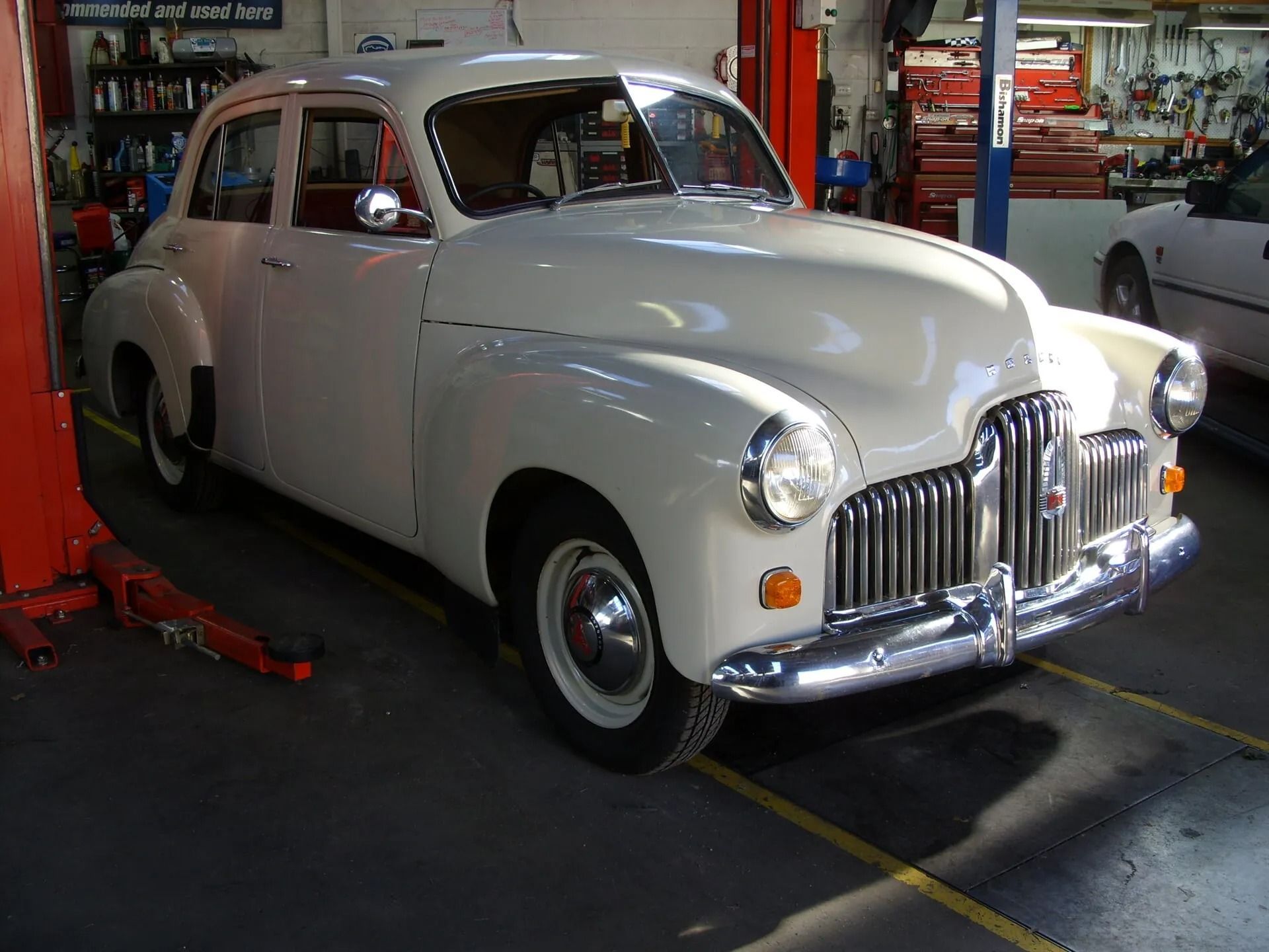 A white classic car is on a Stand in a Garage — Mechanical World In Wagga Wagga, NSW
