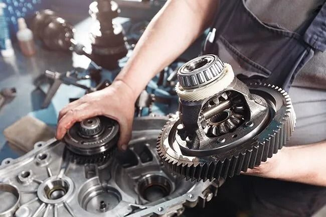 A Man is Working on a Gearbox in a Garage — Mechanical World In Wagga Wagga, NSW