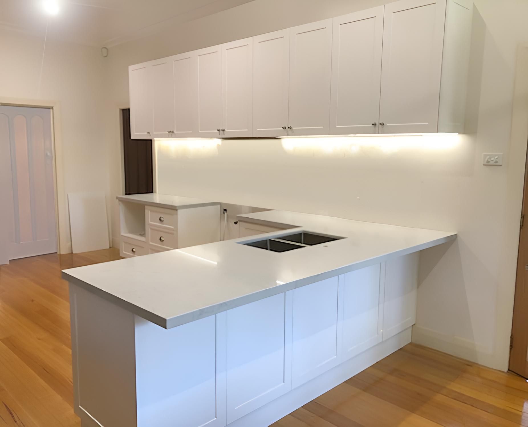 A Kitchen With White Cabinets and a White Counter Top — BM Cabinetry In Spring Grove, NSW