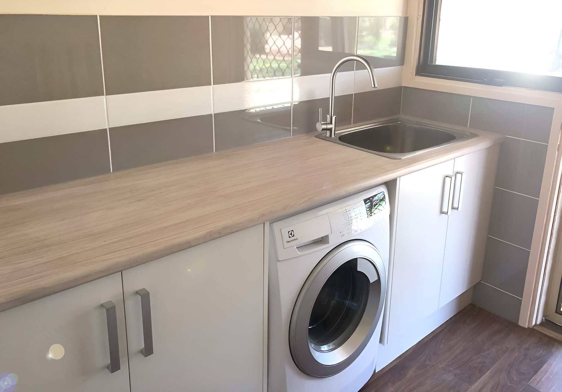 A Kitchen With a Sink, Washer and Dryer — BM Cabinetry In Spring Grove, NSW