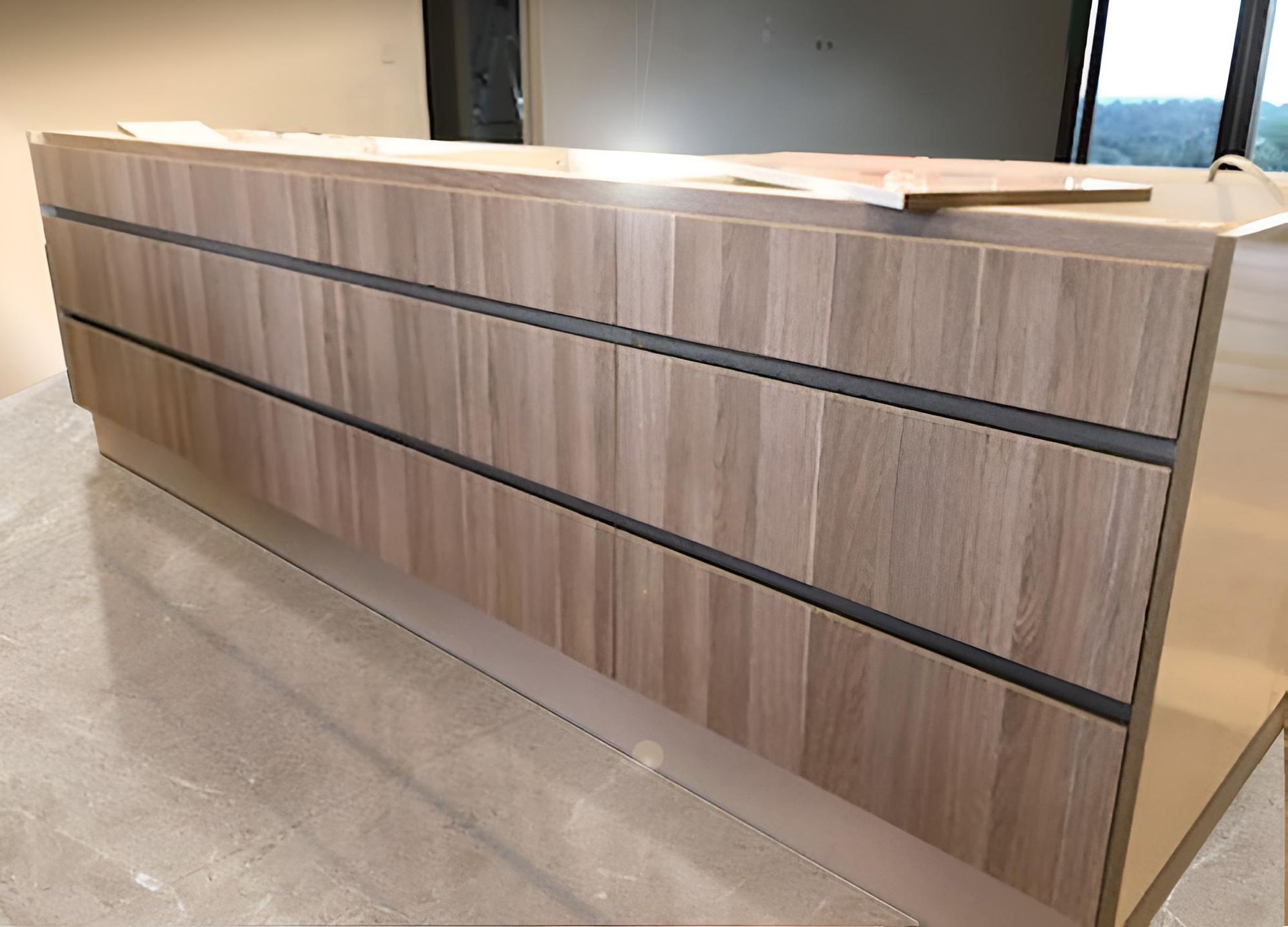 A Wooden Counter With Drawers is Sitting on the Floor in a Room — BM Cabinetry In Spring Grove, NSW