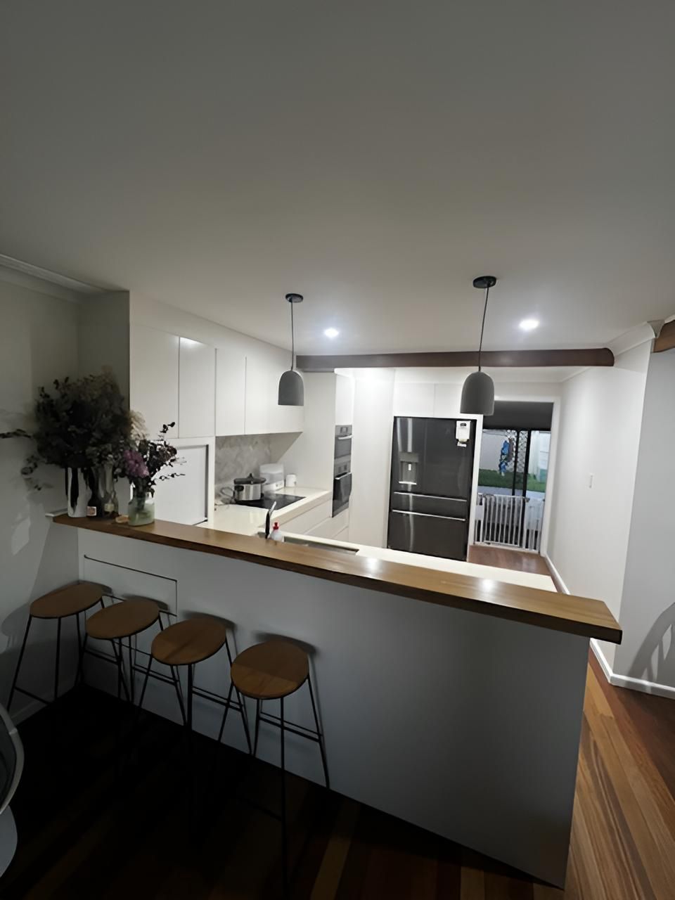 A Kitchen With White Cabinets and Wooden Stools — BM Cabinetry In Spring Grove, NSW