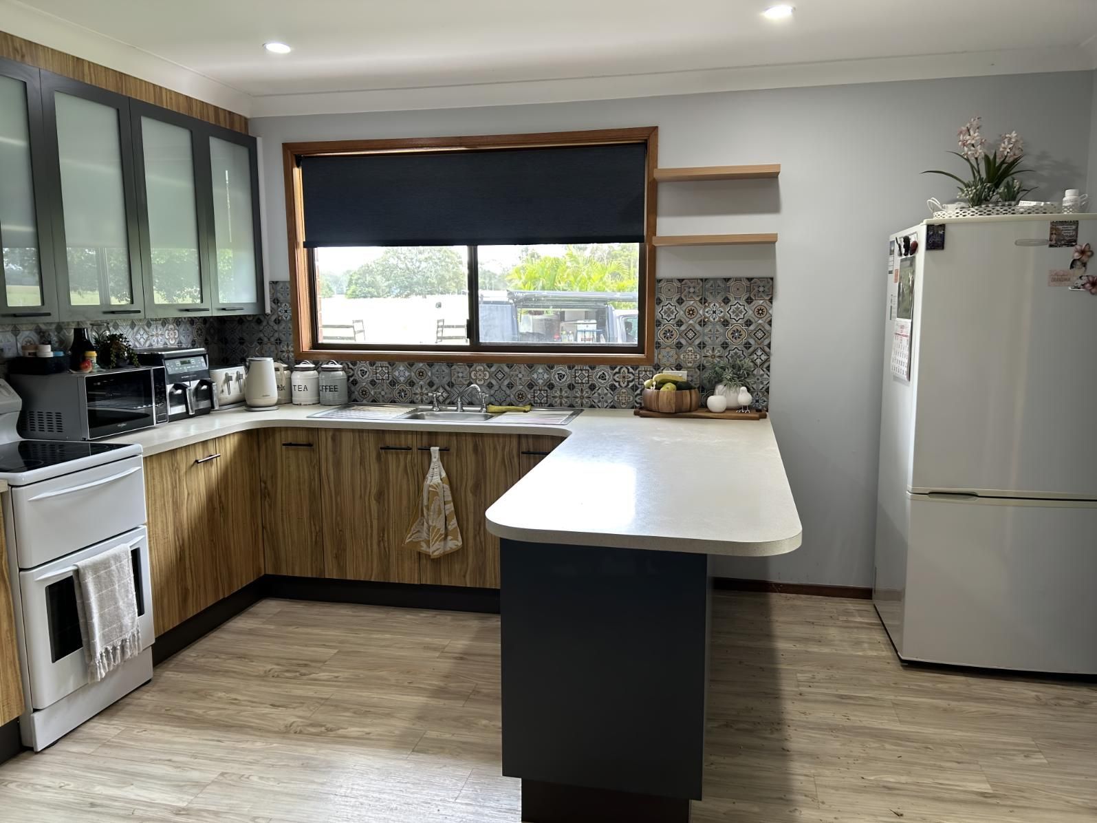 A Kitchen With Wooden Cabinets, a Stove , a Refrigerator , and a Window — BM Cabinetry In Spring Grove, NSW