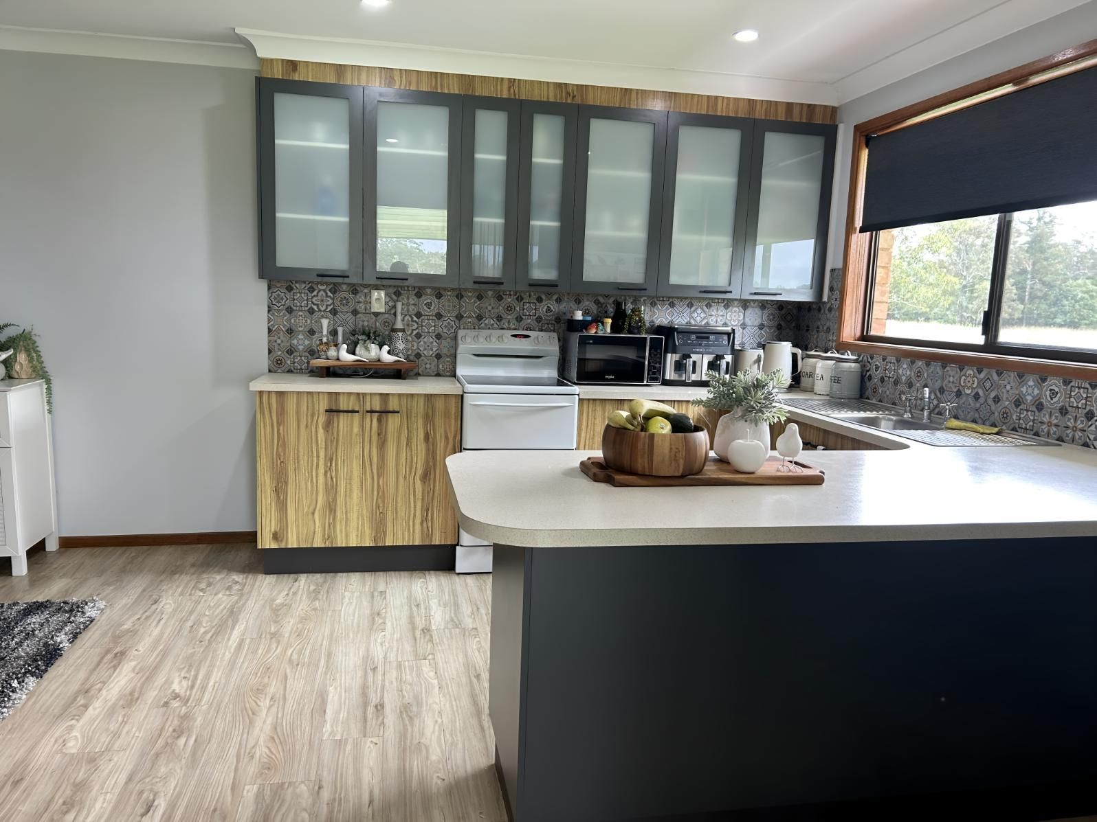 A Kitchen With Wooden Cabinets and a Large Island in the Middle — BM Cabinetry In Spring Grove, NSW